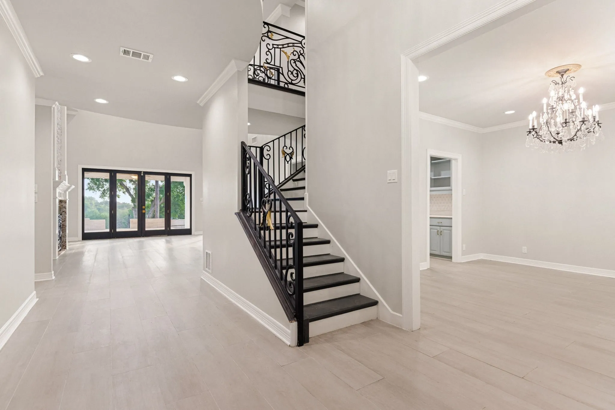 Grand entry featuring a wrought iron staircase, wood-finish flooring, and recessed lighting