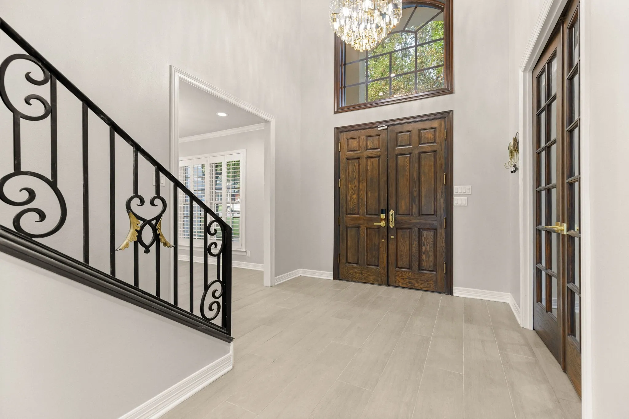 Grand entryway featuring double-door entry, a two-story ceiling, and tile flooring