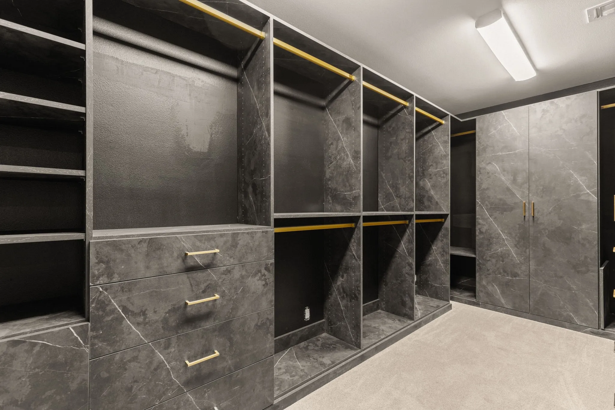 Custom closet system featuring dark stone-look finishes