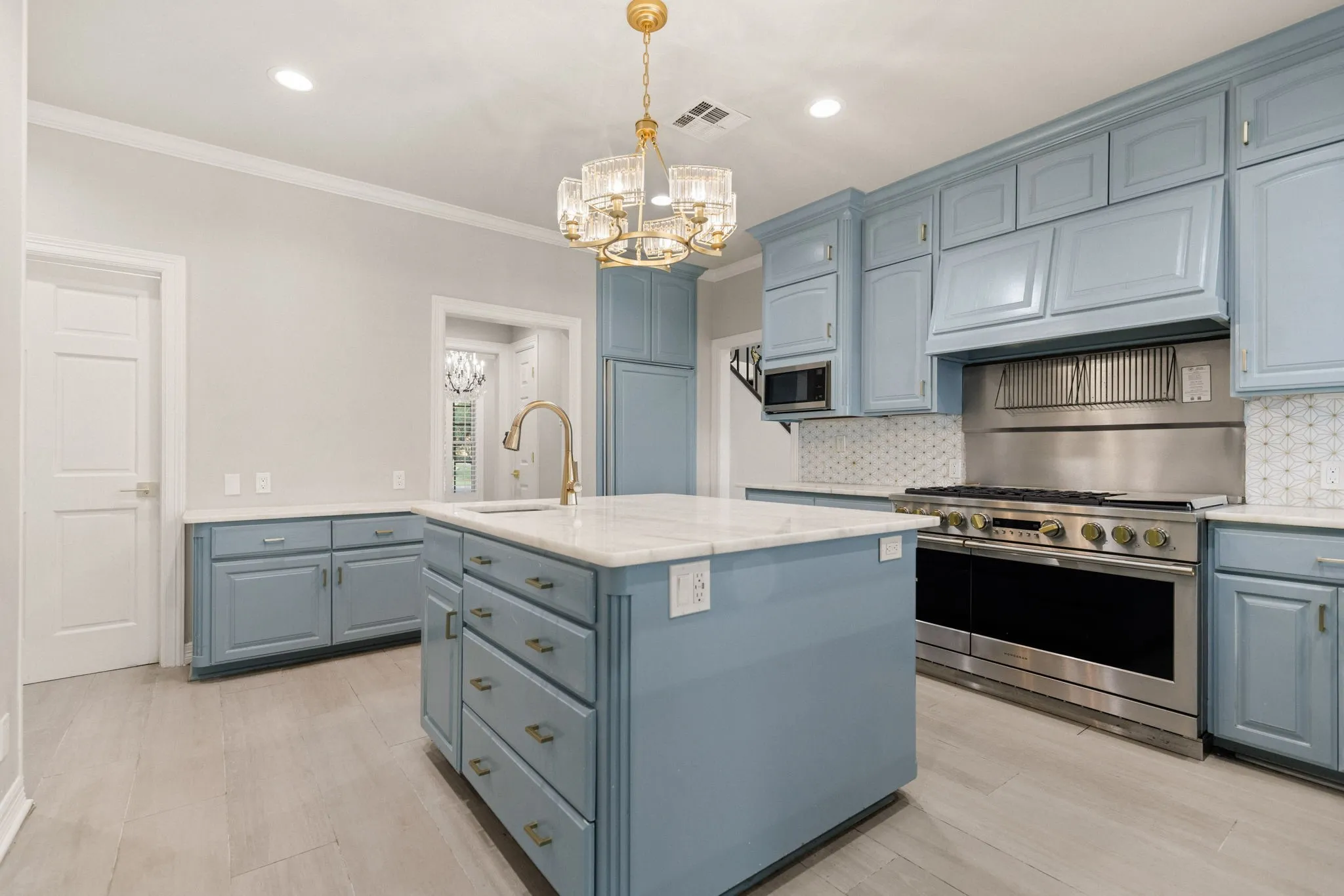 Kitchen featuring light blue cabinetry, white countertops, and wood-finish flooring