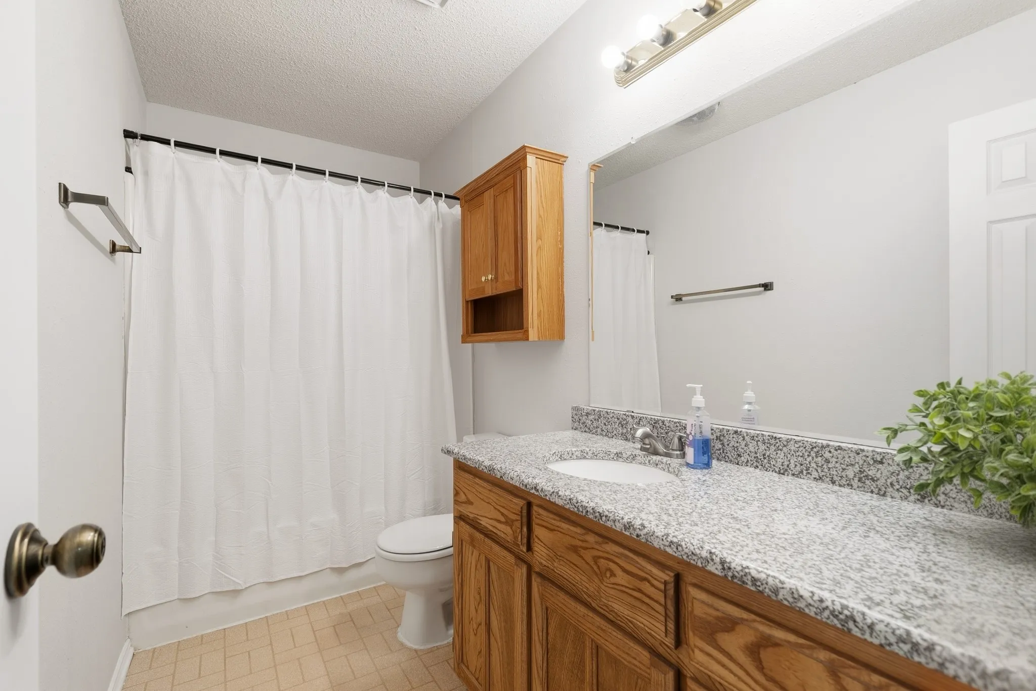 Bathroom featuring a wood vanity with a built-in sink and a light-toned speckled countertop