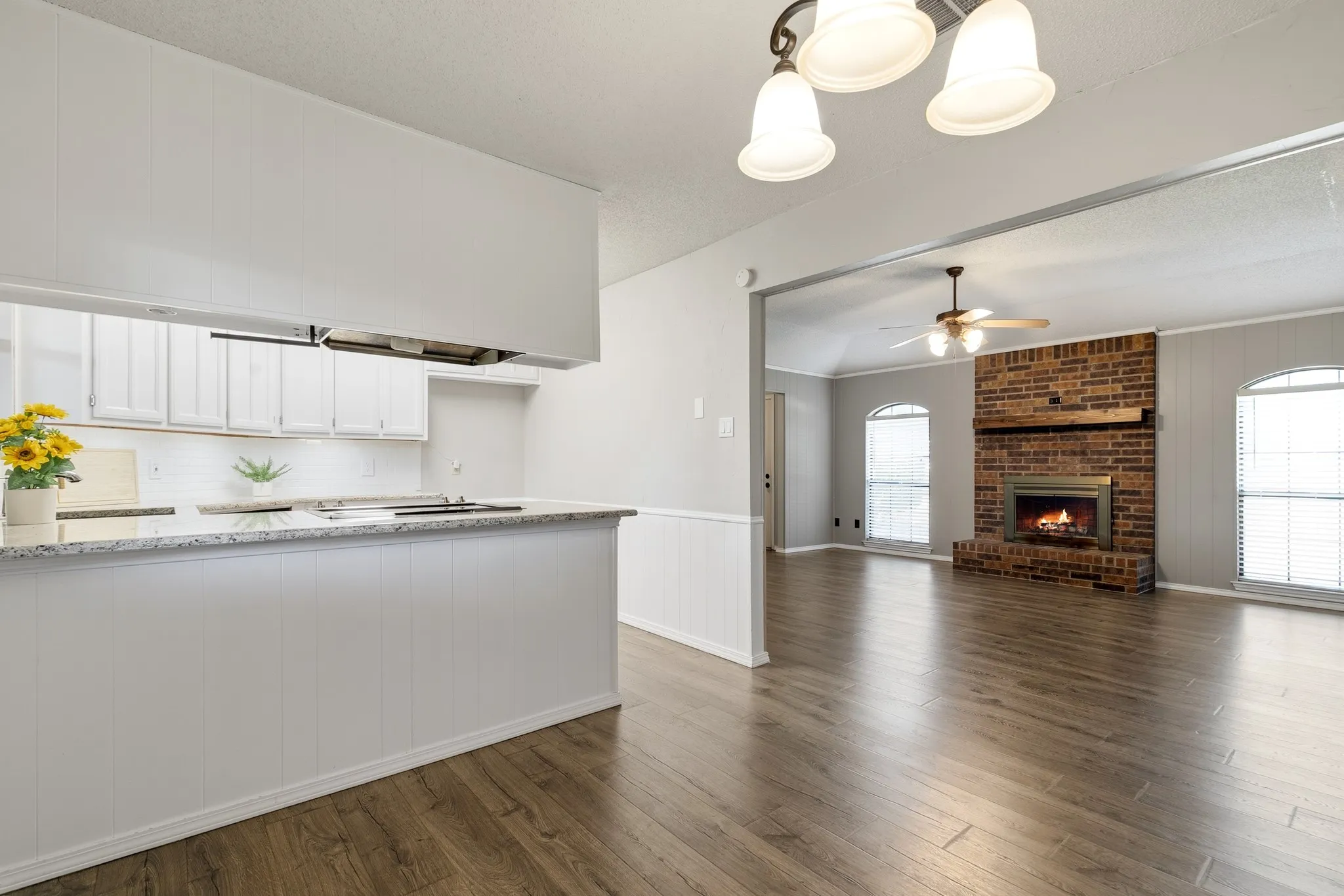 Kitchen peninsula featuring a granite-style countertop, white cabinetry, and white subway tile backsplash