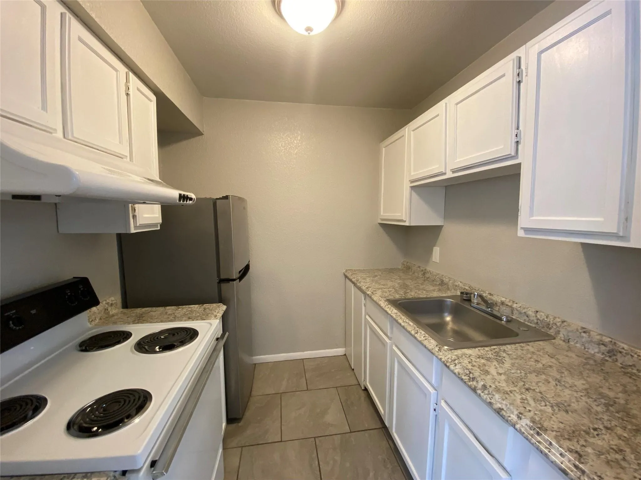 Discover a beautifully updated kitchen featuring crisp white cabinetry, attractive countertops, and modern appliances, perfect for culinary endeavors.