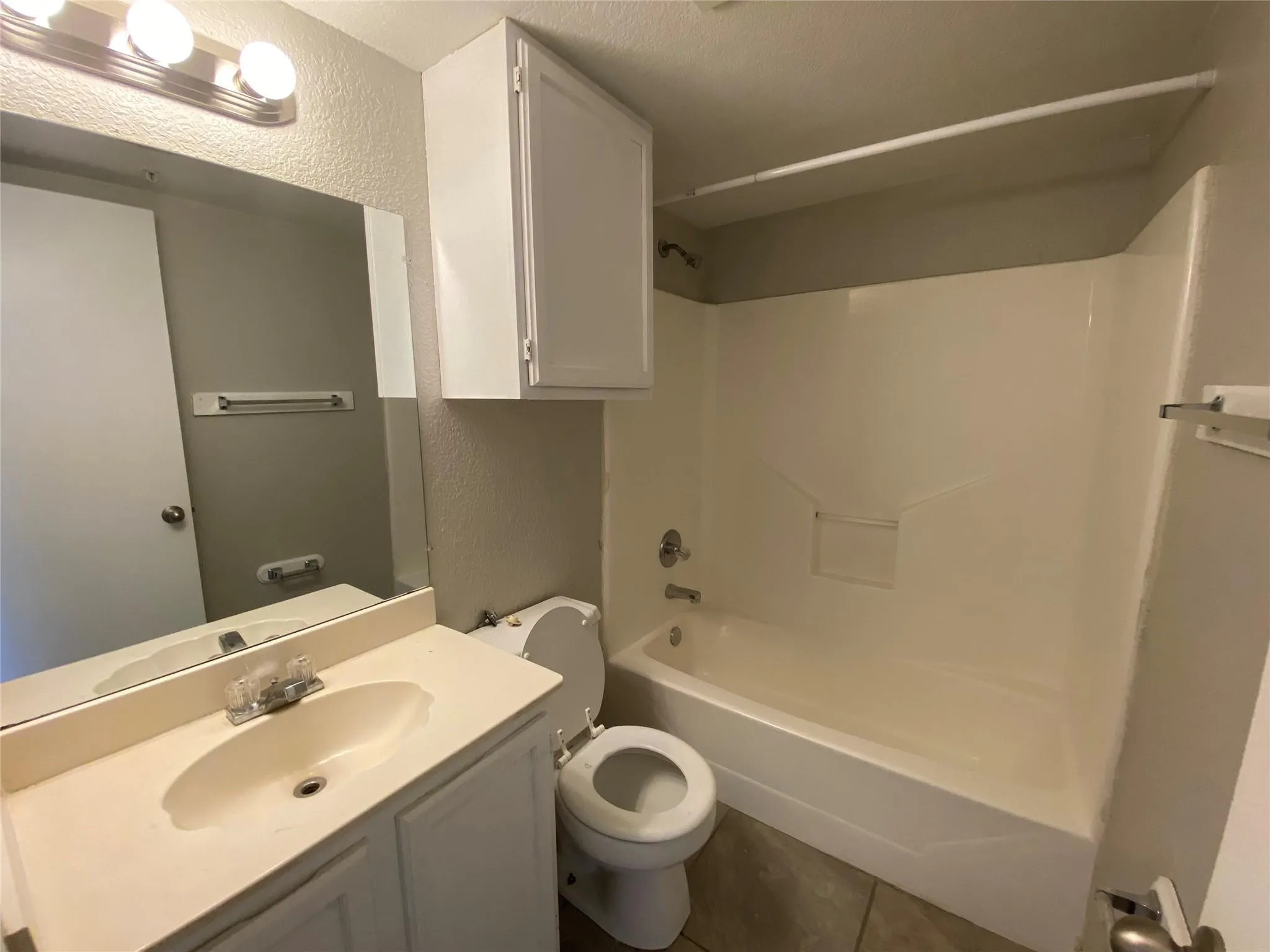 Step into this bright and tidy bathroom, complete with a clean vanity, convenient storage, and a fresh shower/tub combination.