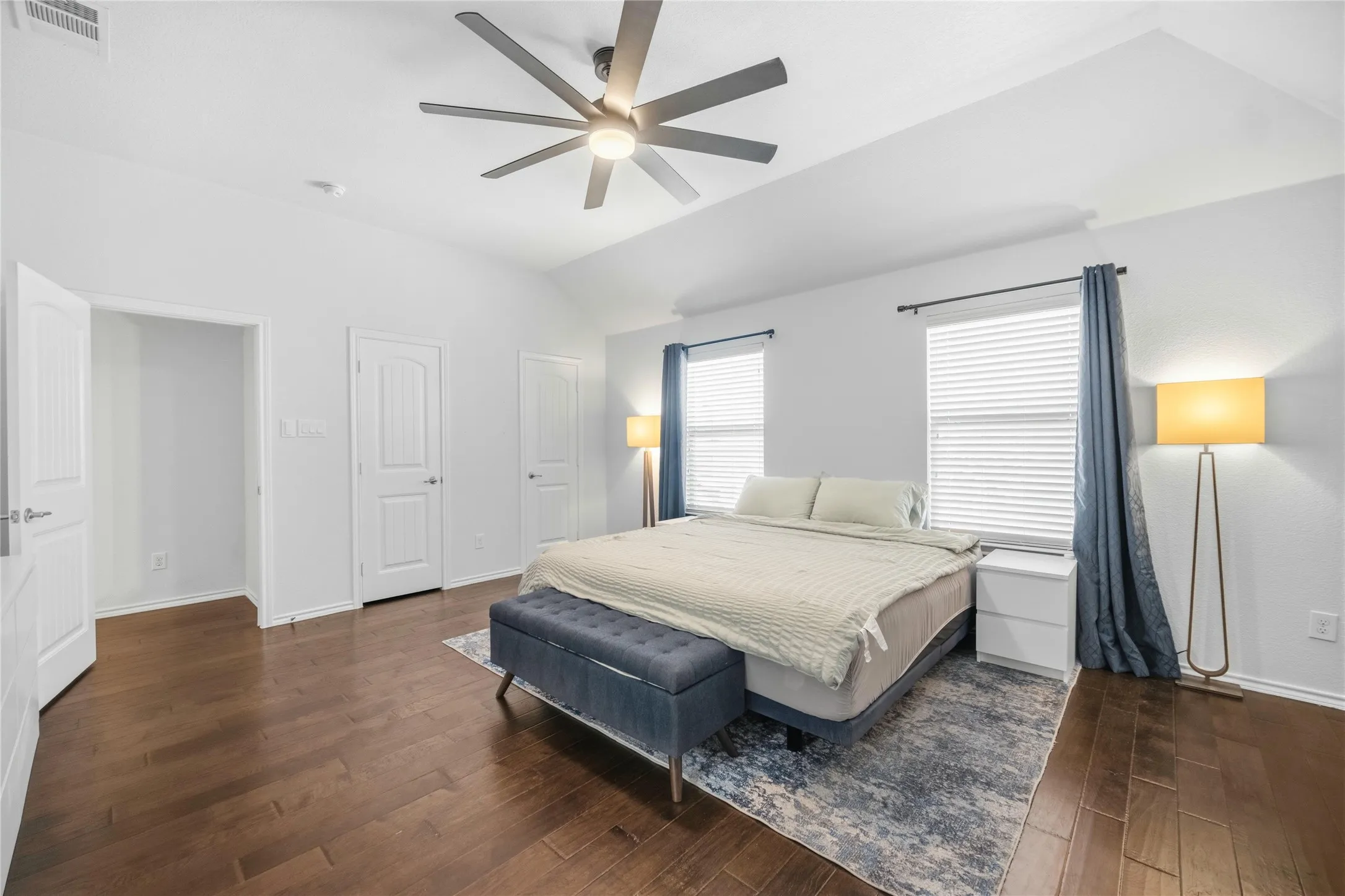 Spacious room featuring vaulted ceilings and dark wood-finish flooring