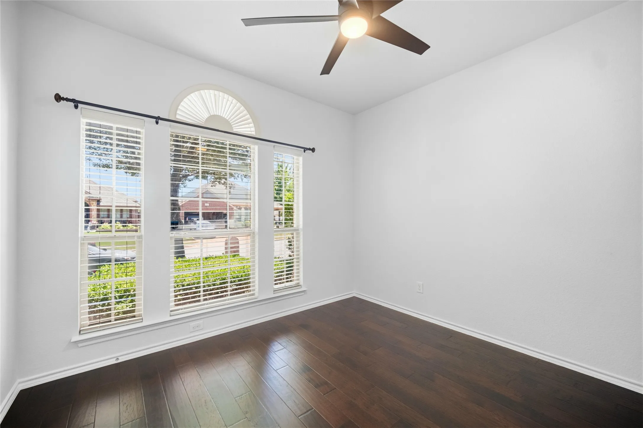 Room featuring wood-finish flooring, white baseboards, and a contemporary ceiling fan