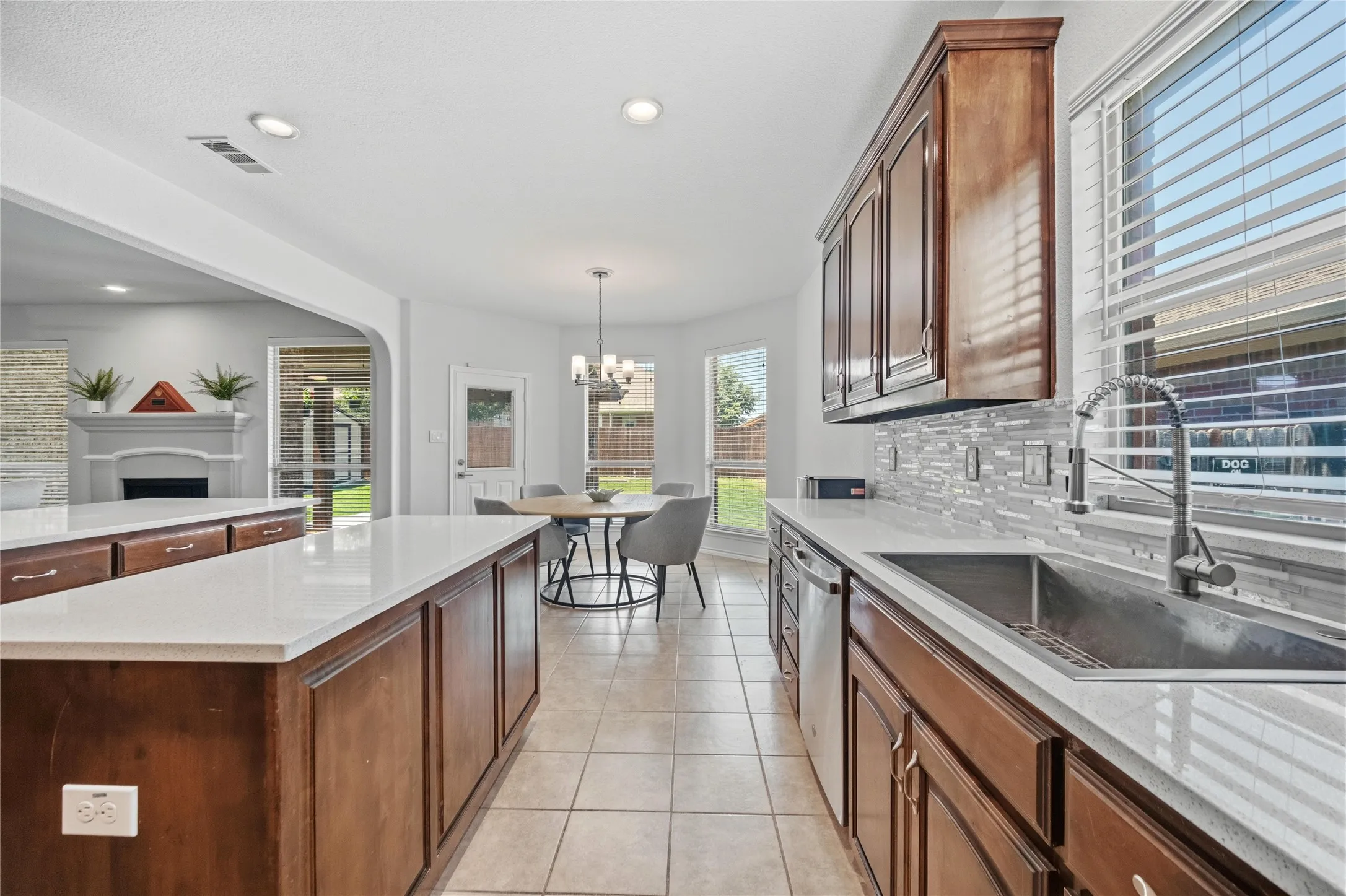 Kitchen featuring wood cabinetry, light countertops, and a tiled backsplash