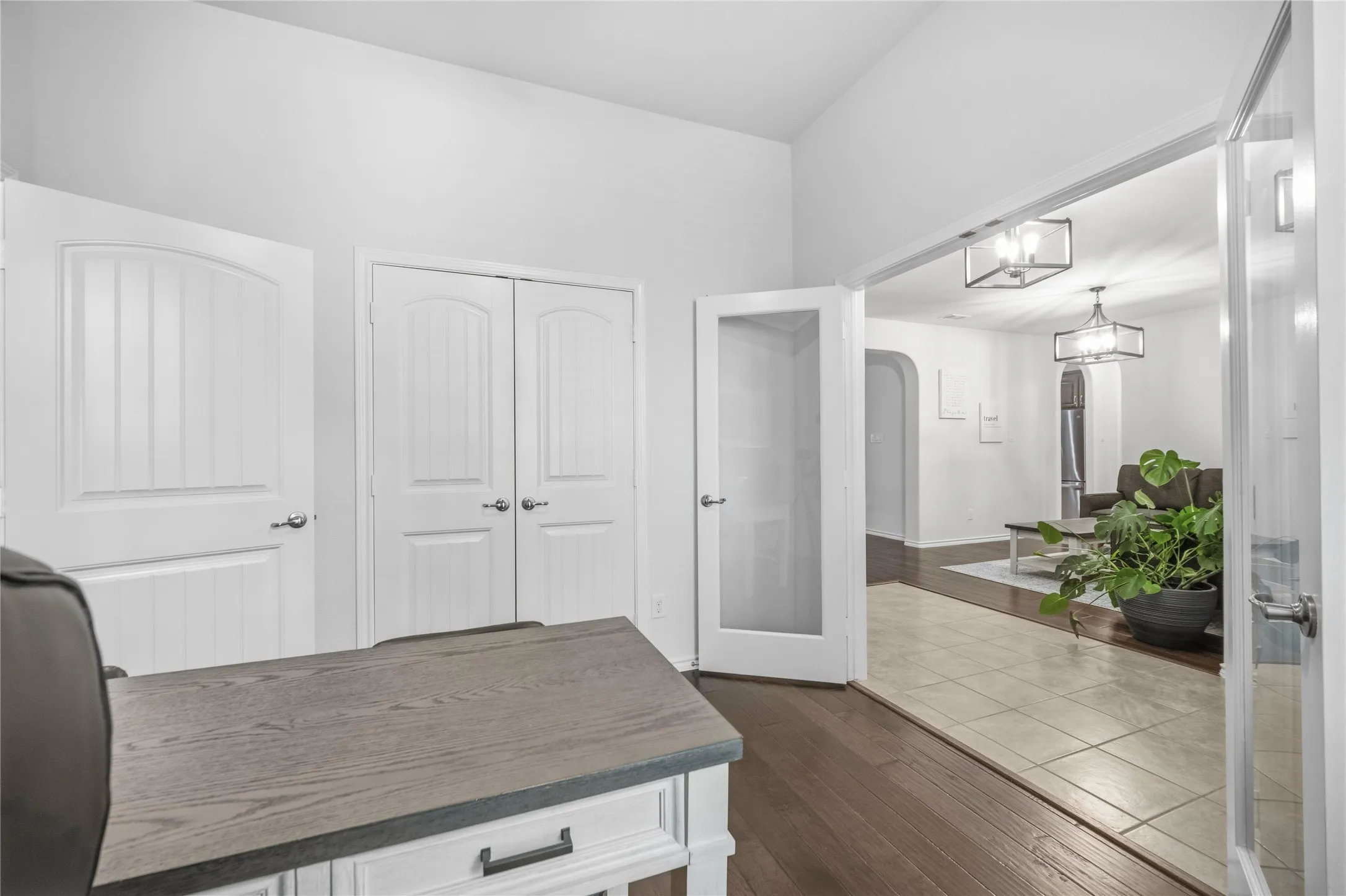 Room featuring dark wood-finish flooring, white paneled doors, and double French doors with frosted glass