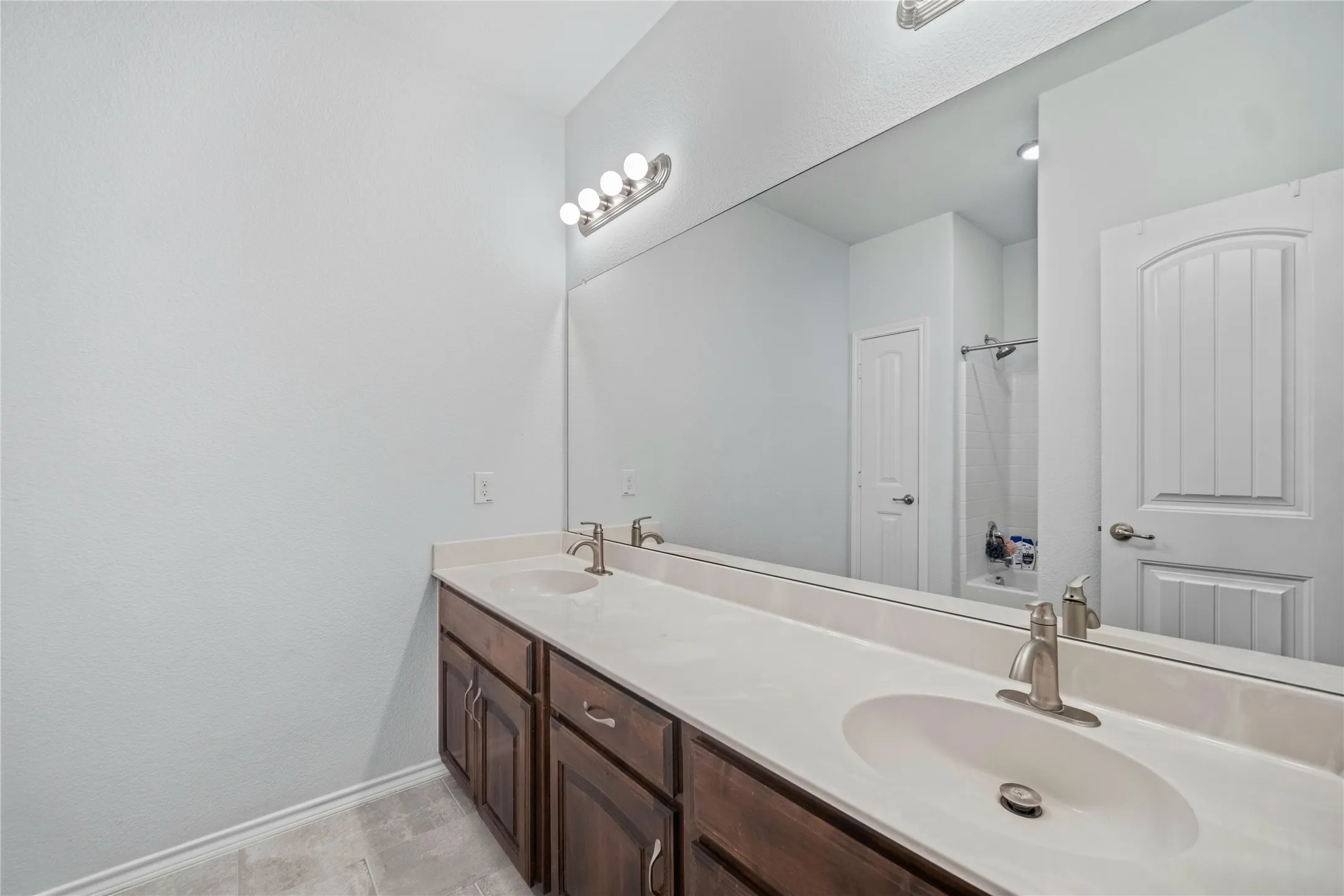 Dual vanity with under-mount sinks and brushed nickel faucets, set in a light-toned countertop