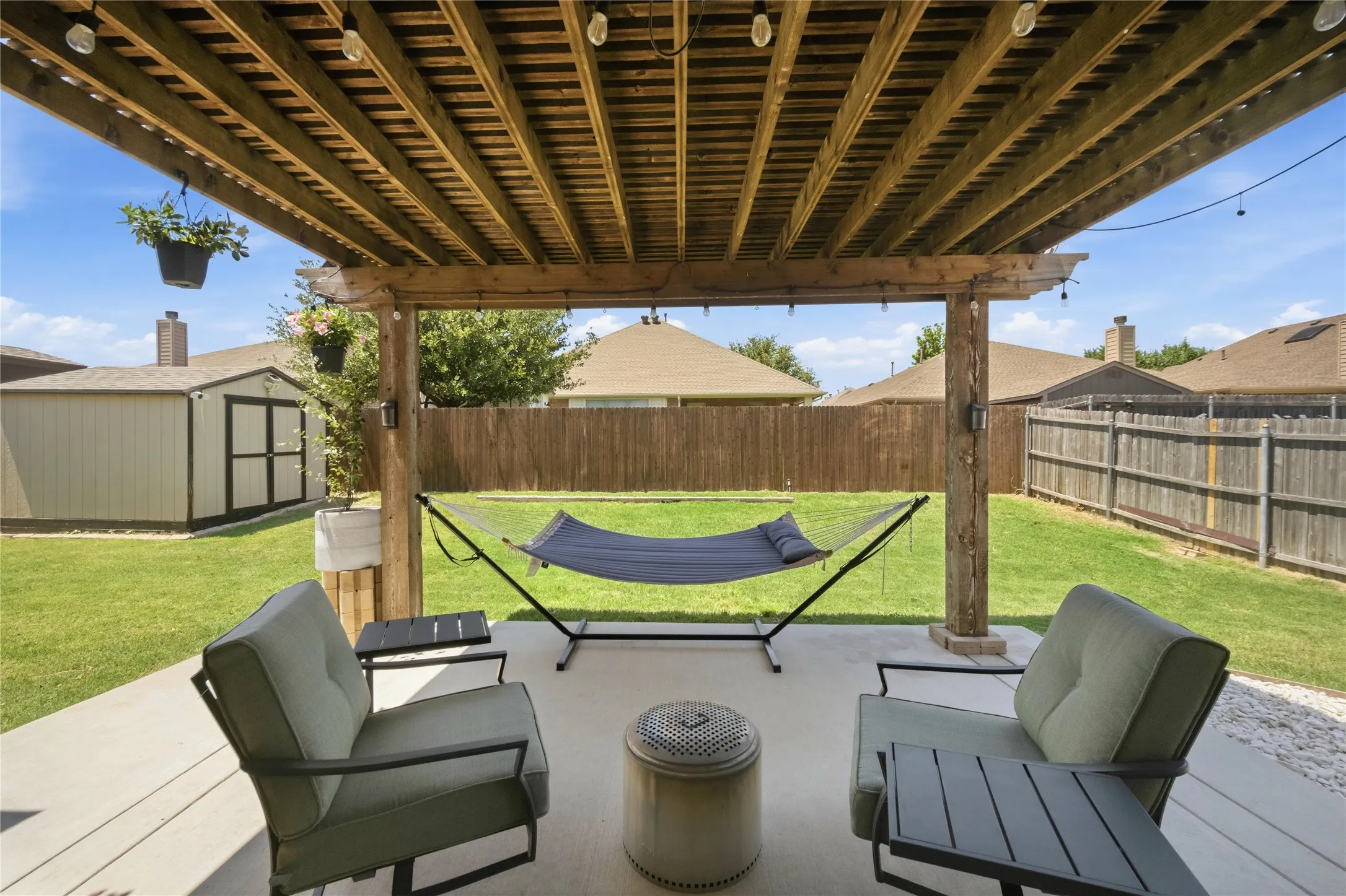 Expansive covered patio featuring a wood pergola and concrete flooring