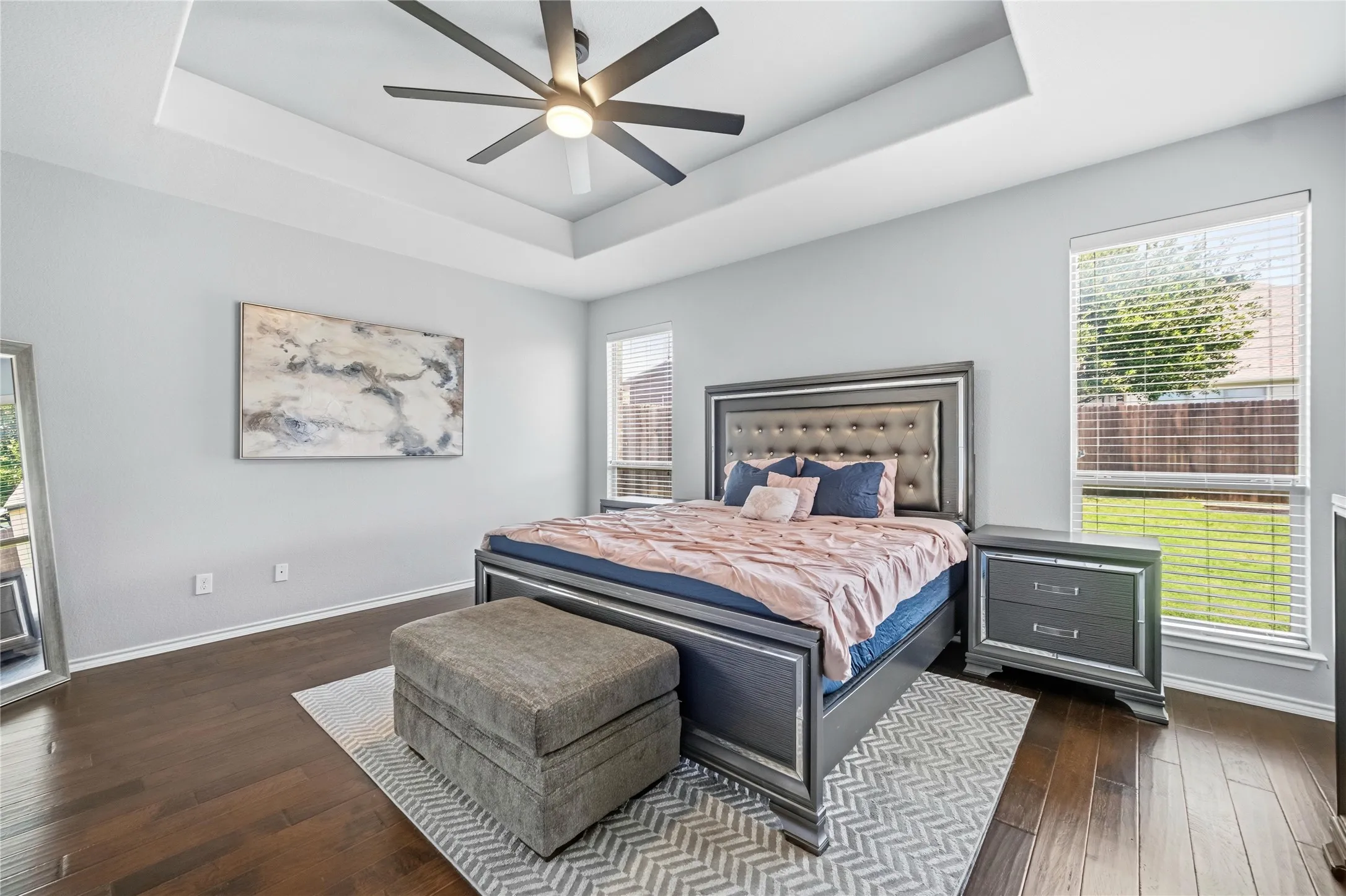 Room with a tray ceiling and a ceiling fan