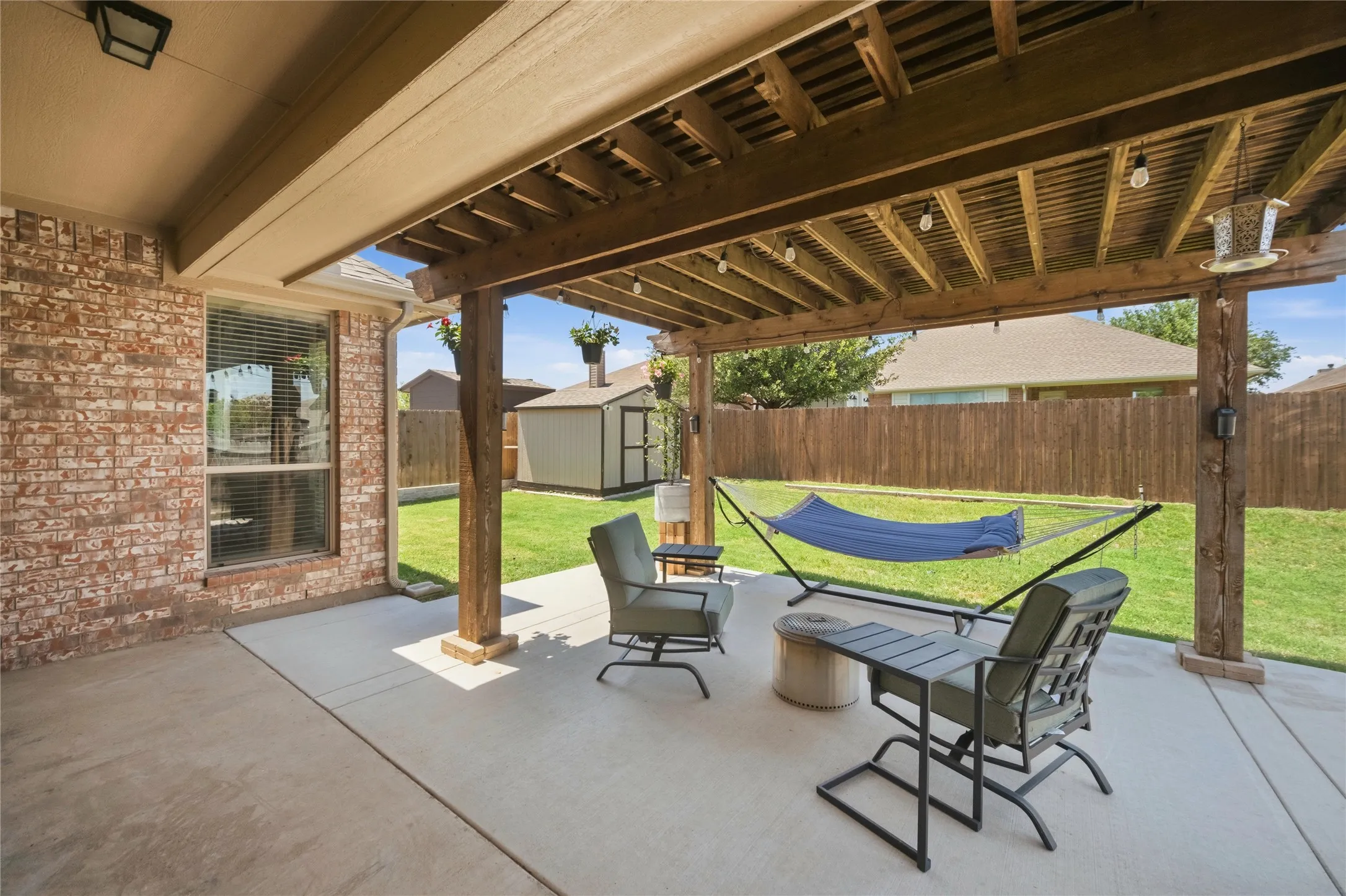 Covered patio featuring a wood pergola, string lighting, and a concrete surface