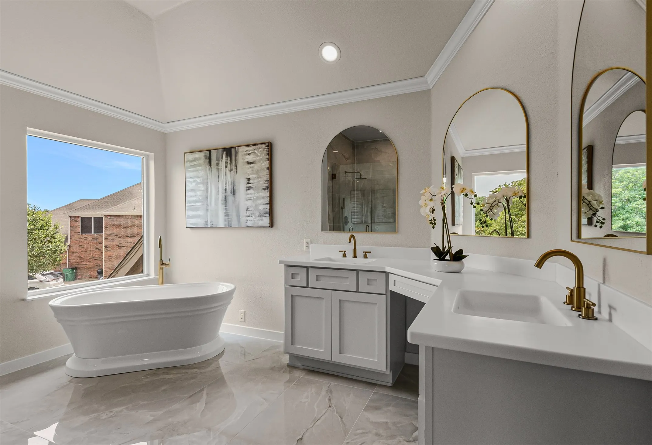 Freestanding soaking tub with a floor-mounted gold-finish faucet