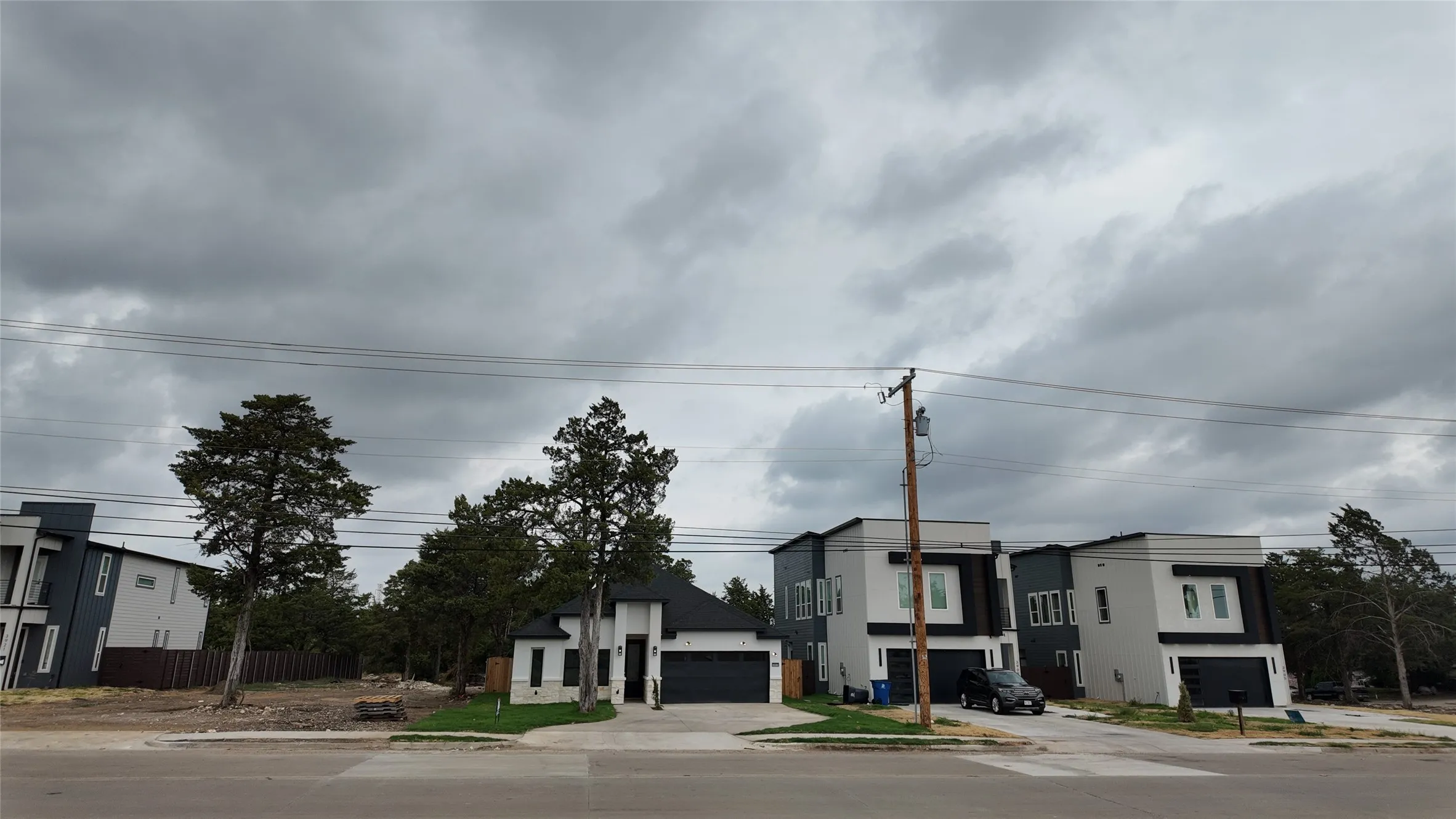 Modern architectural homes featuring contrasting exterior finishes and attached garages