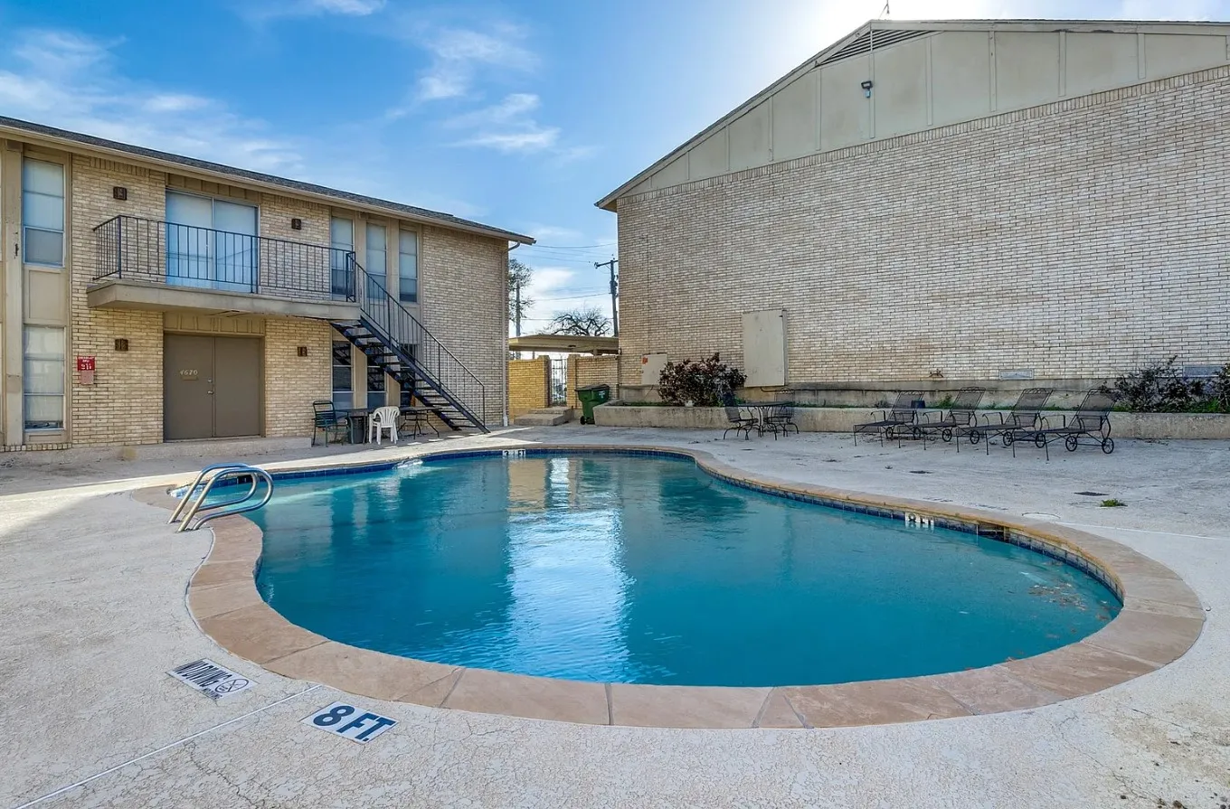Curved swimming pool with concrete decking and coping