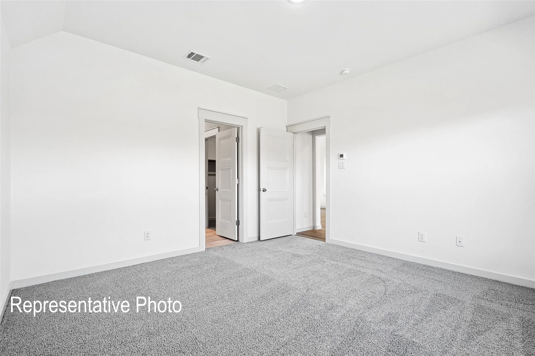 Bedroom featuring gray carpeting, white painted walls, and white trim