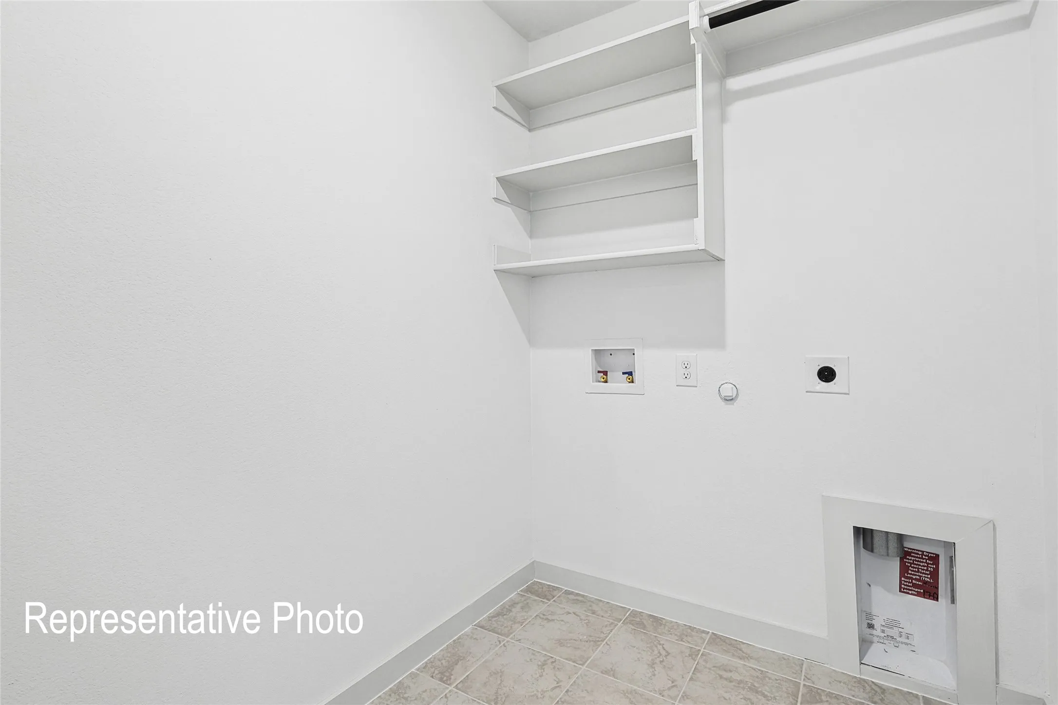 Dedicated laundry area featuring white shelving, a built-in hanging rod, appliance hookups, and tiled flooring