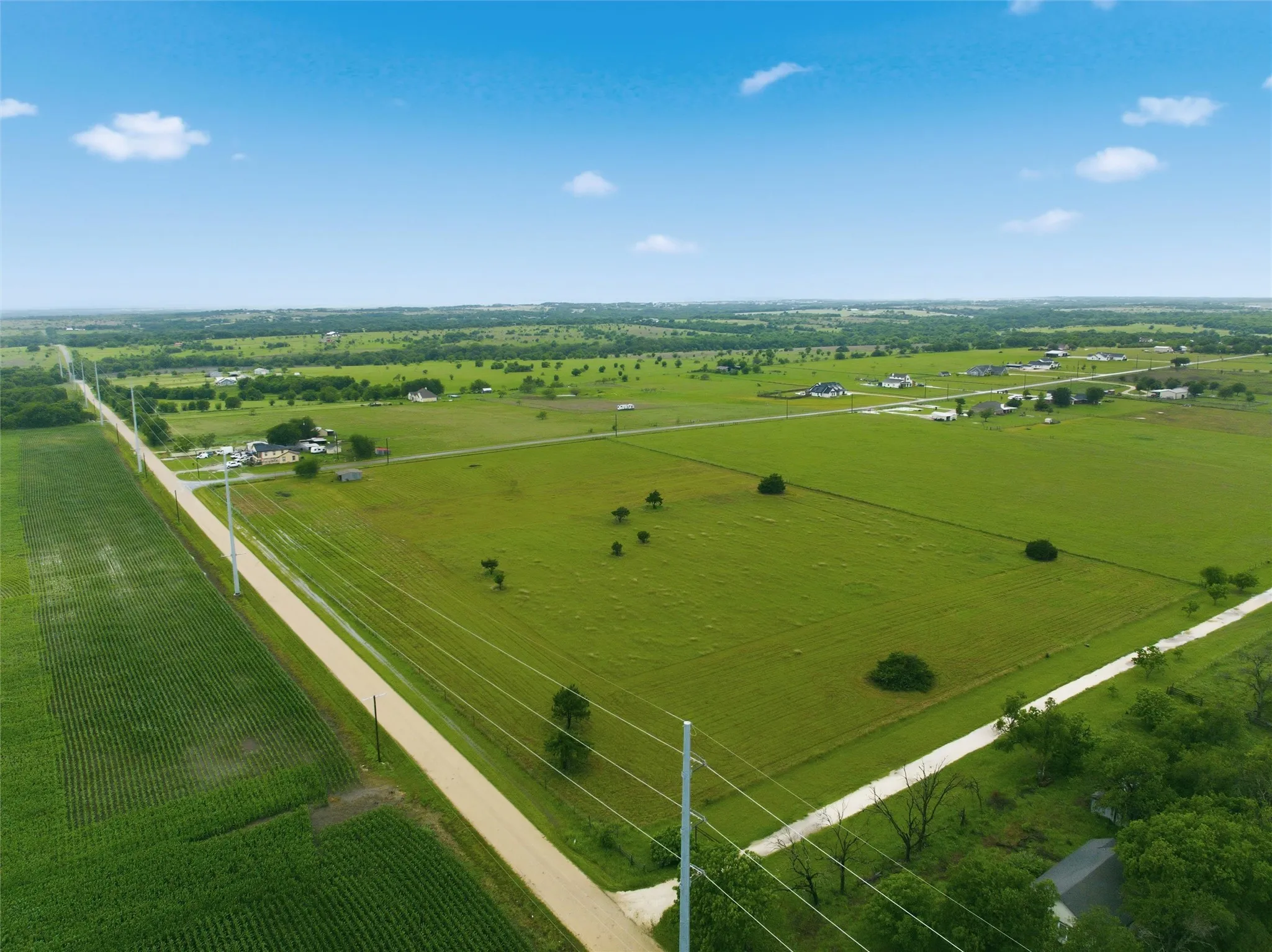 Expansive land parcel featuring verdant fields and a clear sky backdrop