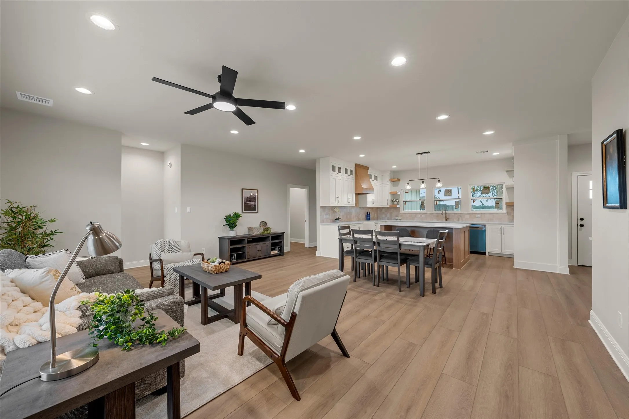 Open-concept living area featuring wood-finish flooring, recessed lighting, and a contemporary ceiling fan