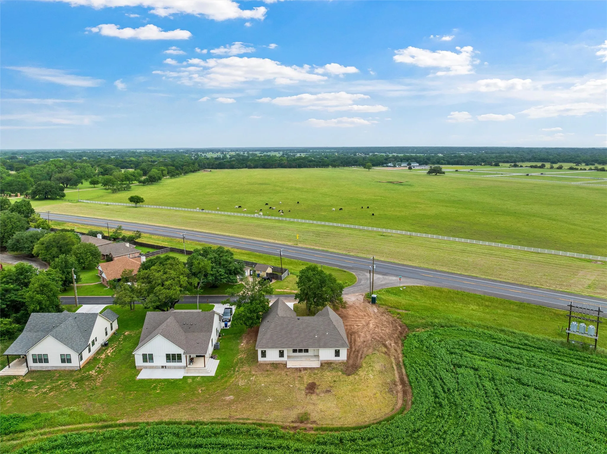 Aerial perspective showcasing a single-story residence with a light-colored exterior and dark-toned roof