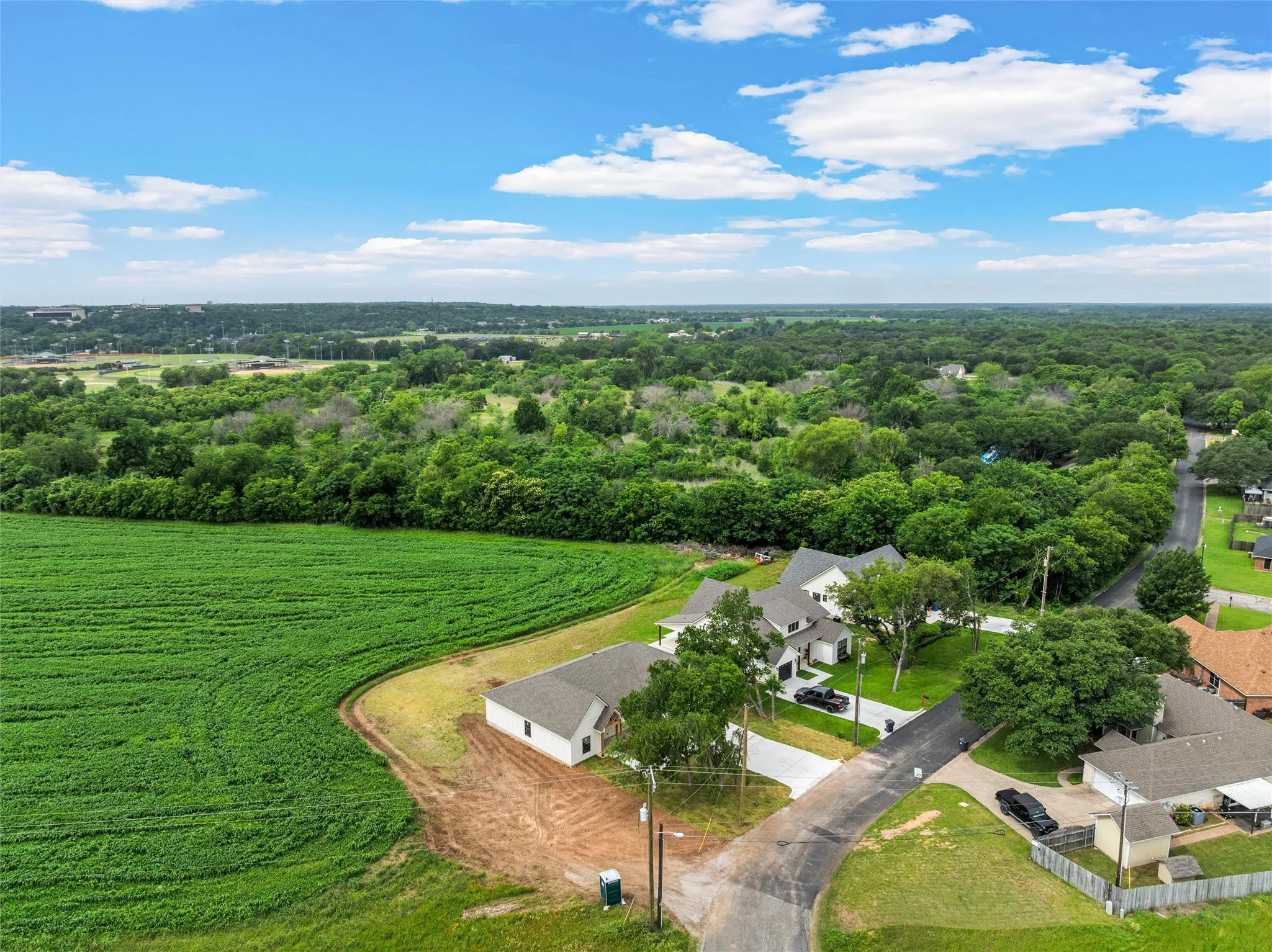 Aerial perspective showcasing new construction homes along a paved road