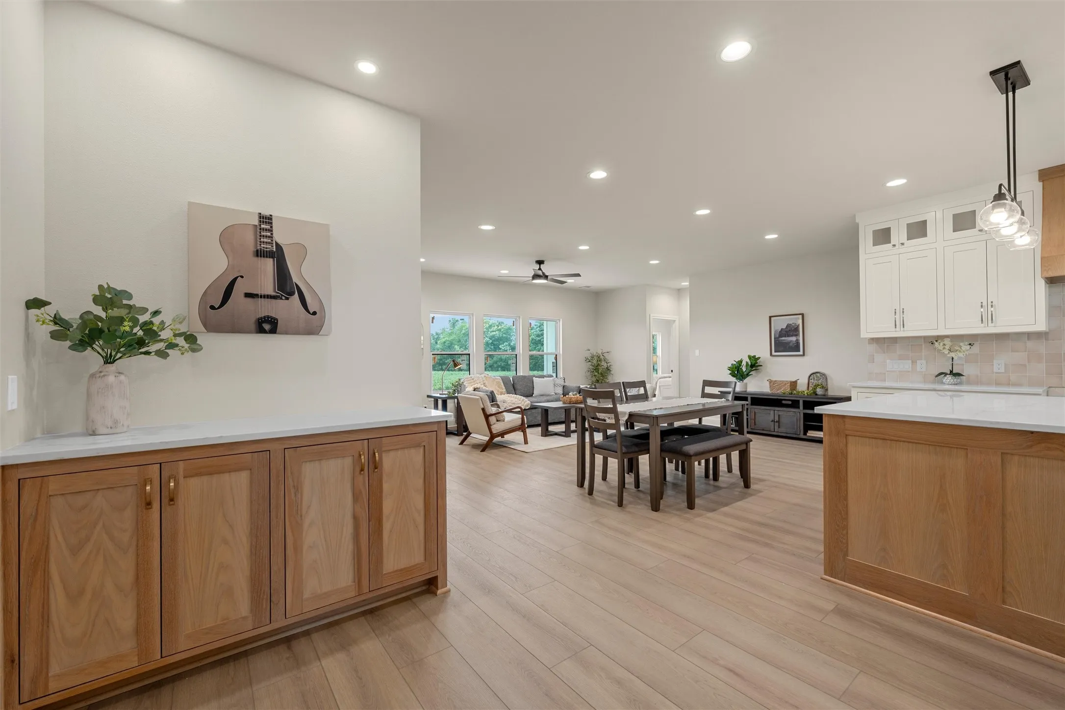 Open-concept living space featuring wood-finish flooring, recessed lighting, and a neutral color palette