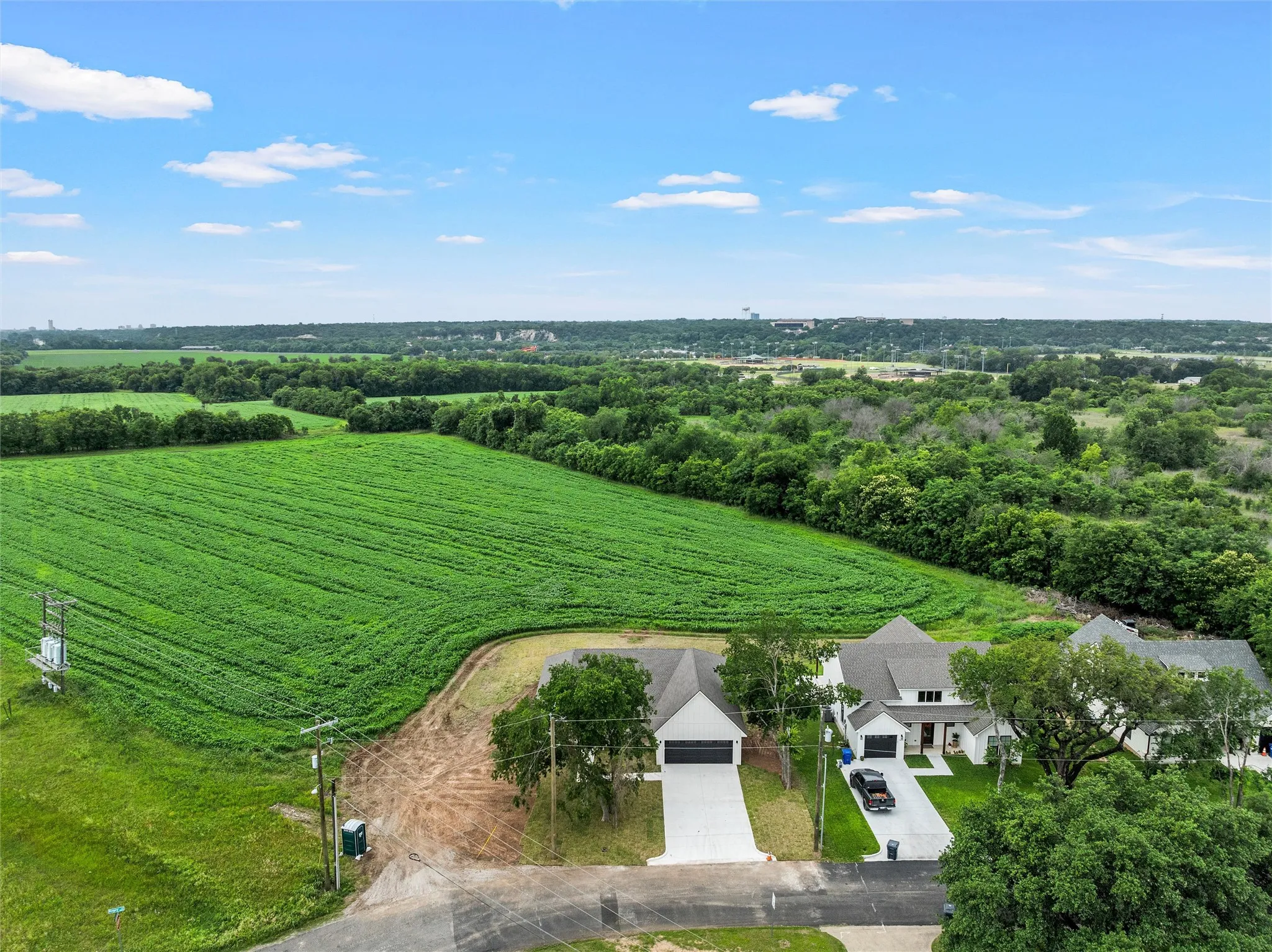 Expansive green fields bordering modern residential properties
