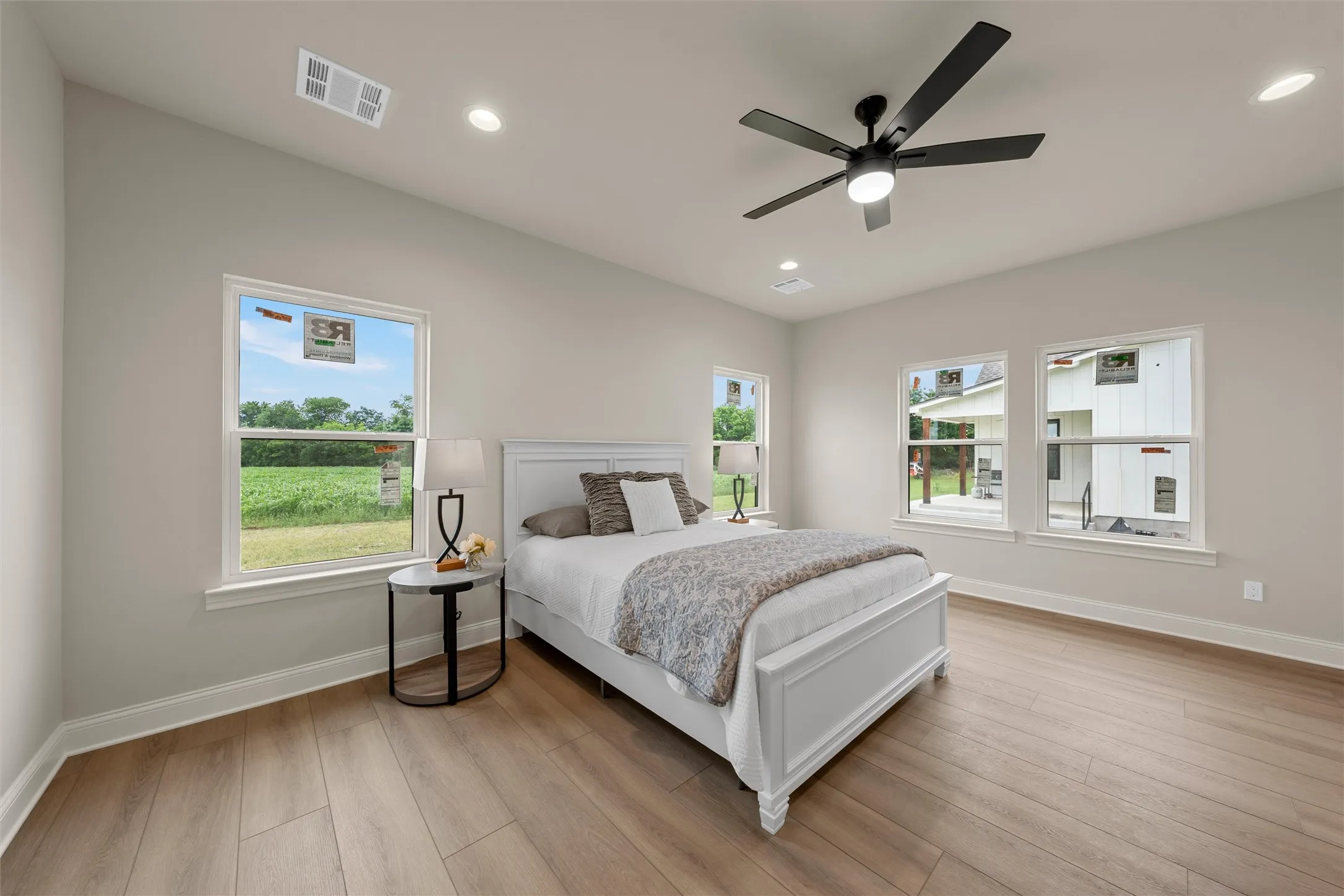 Spacious room featuring wood-finish flooring, vaulted ceiling, and multiple windows