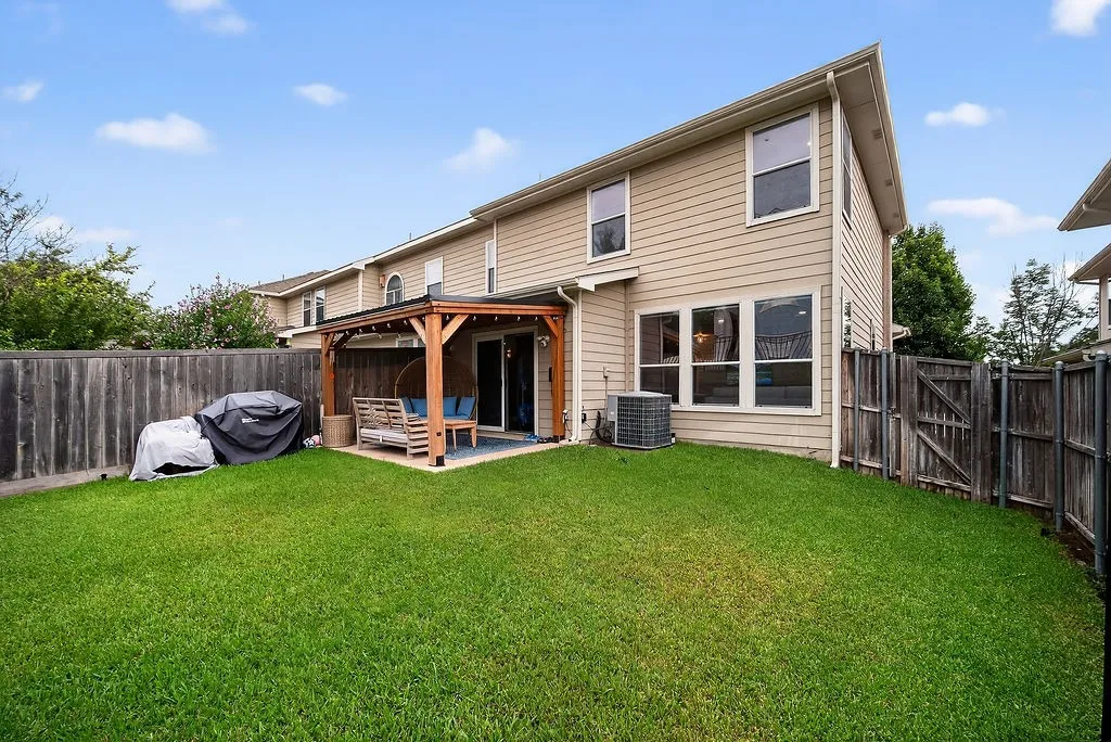 Expansive green lawn with a wood fence perimeter