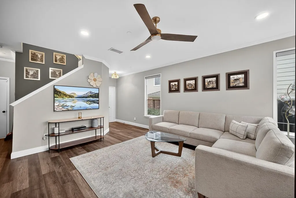 Open-concept living space featuring wood-finish flooring, recessed lighting, and a ceiling fan