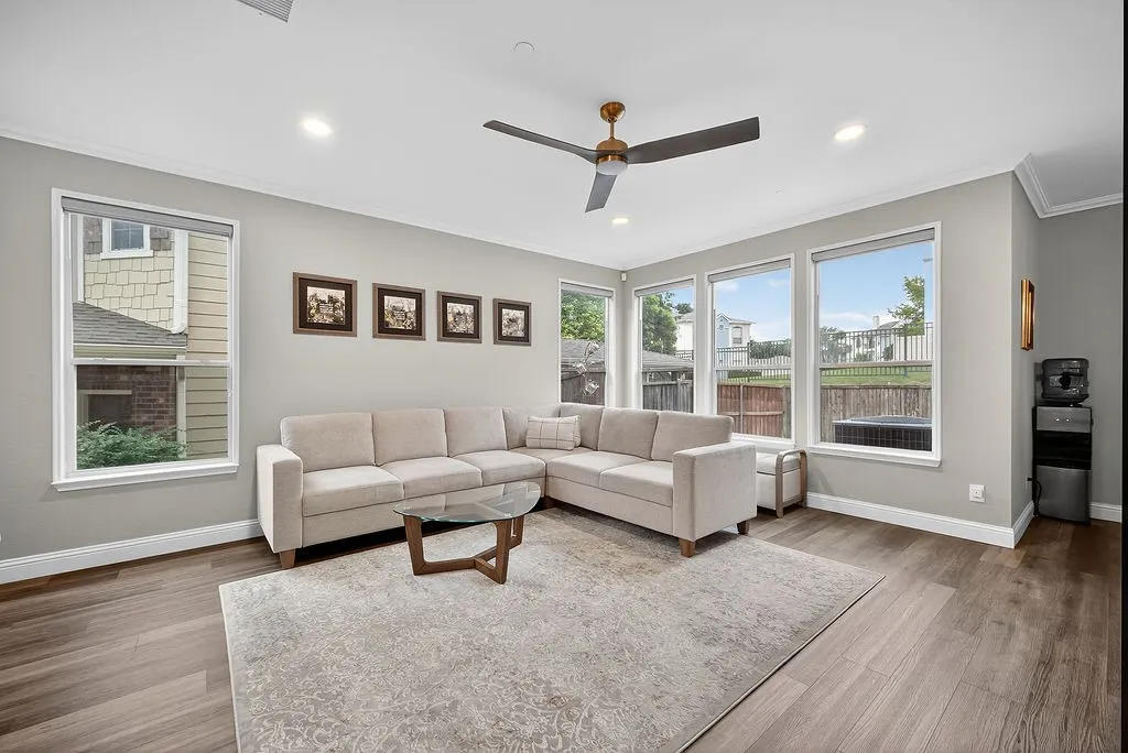Spacious living area featuring wood-finish flooring, recessed lighting, and crown molding