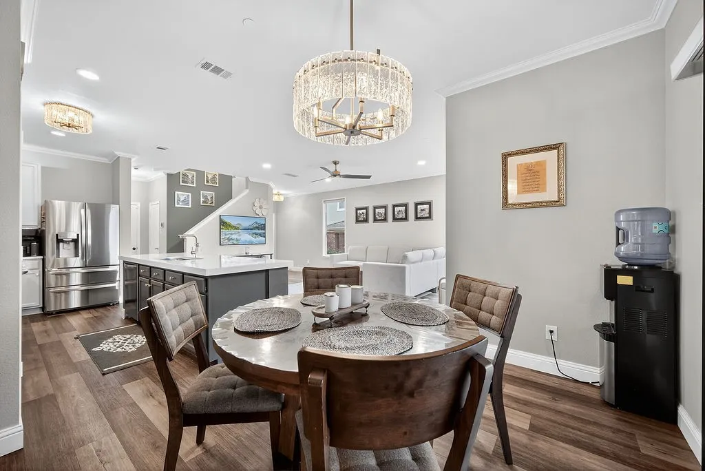 Open-concept living space with wood-finish flooring, a kitchen island, and a decorative chandelier