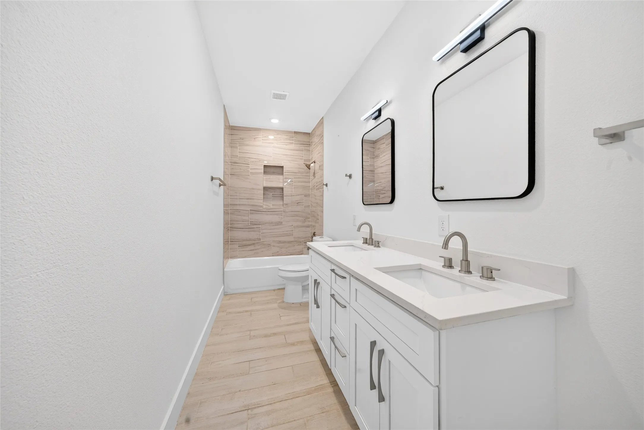 Bathroom featuring a double vanity with stone countertops, undermount sinks, and brushed nickel fixtures
