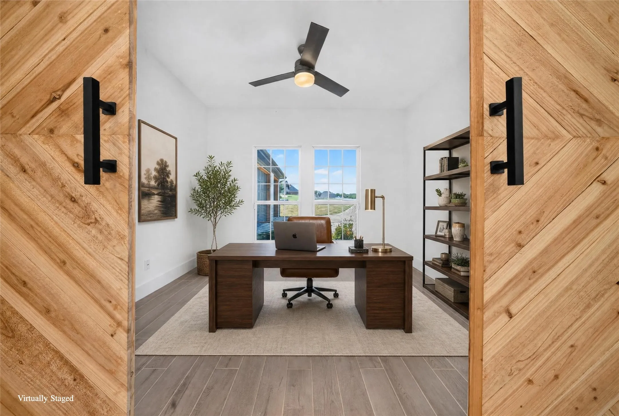 Room framed by a pair of chevron-patterned wood-finish barn doors with matte black hardware
