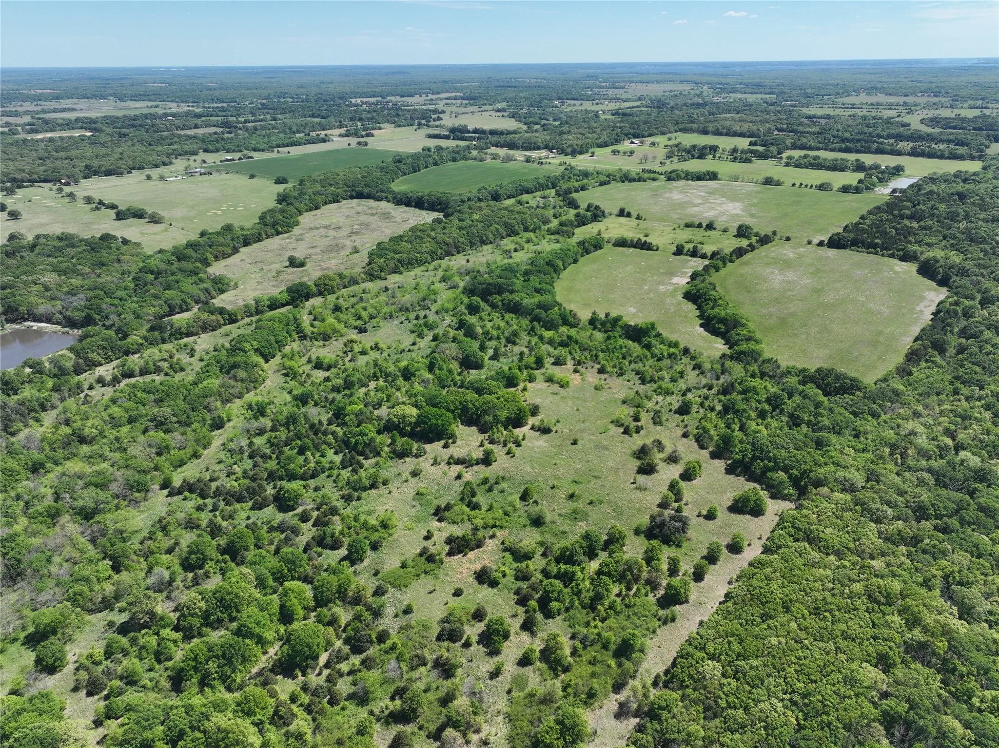 Expansive acreage featuring a mix of mature trees, open clearings, and natural terrain