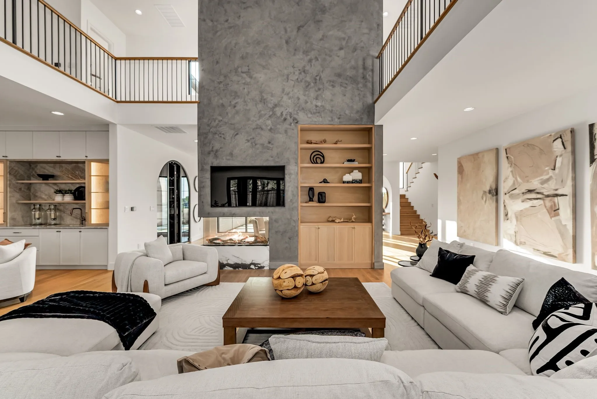 Living area featuring recessed lighting, light wood-type flooring, a towering ceiling, stairway, and a fireplace