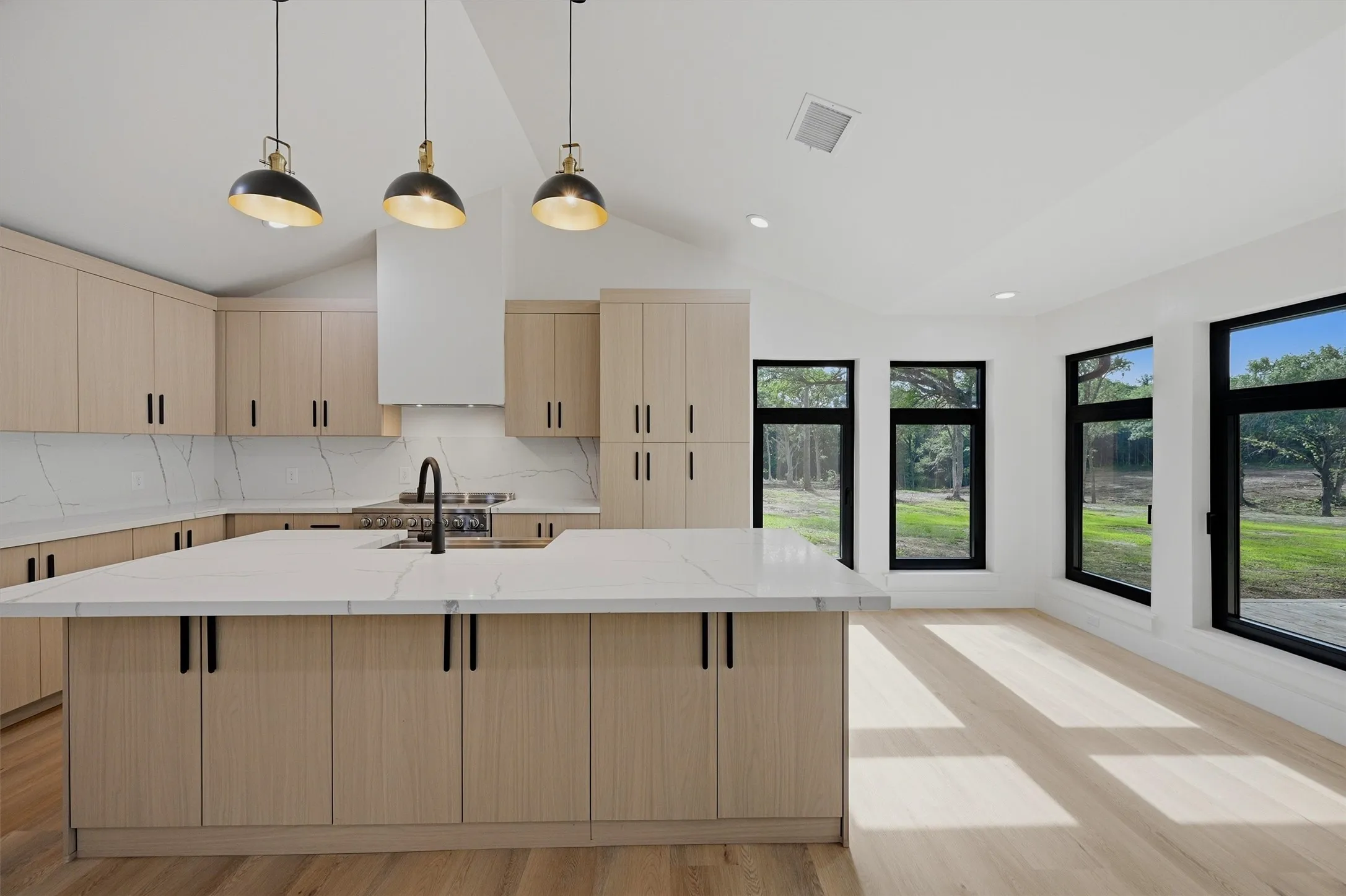 Open-concept kitchen and living area featuring a large center island with a white countertop