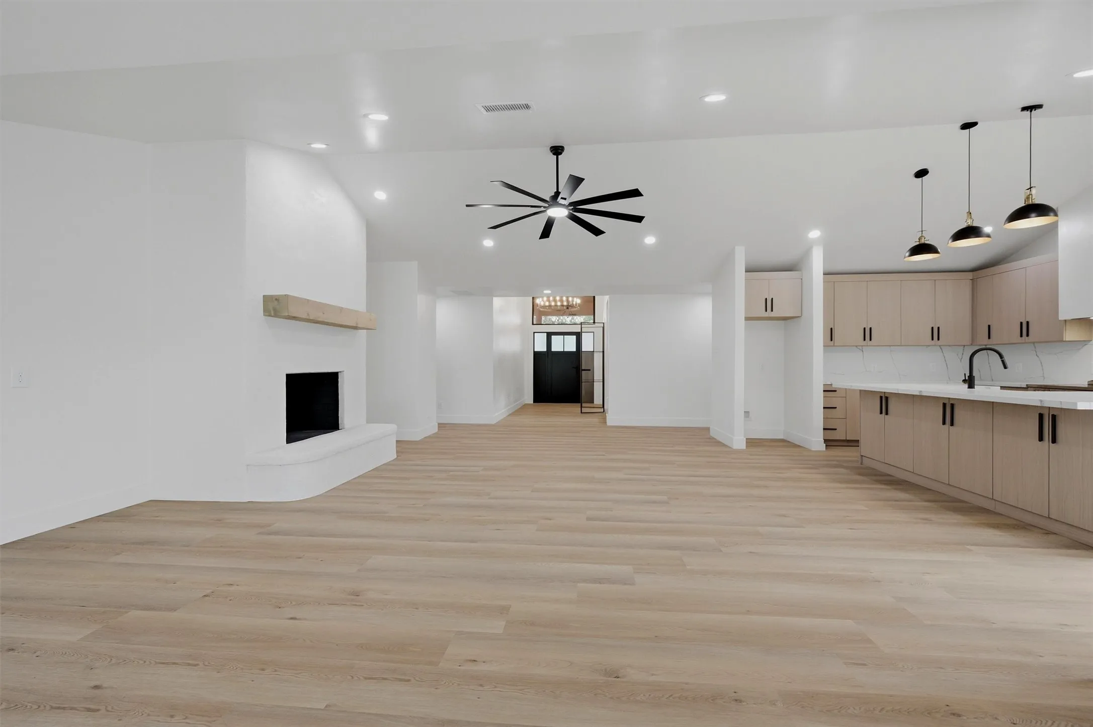Open-concept interior featuring light wood-finish flooring throughout