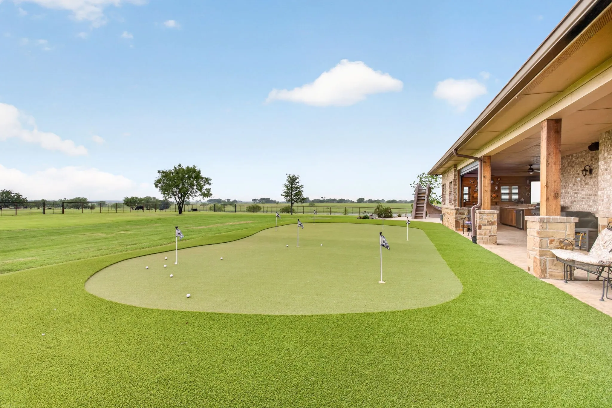 Expansive outdoor area featuring a putting green with multiple flags