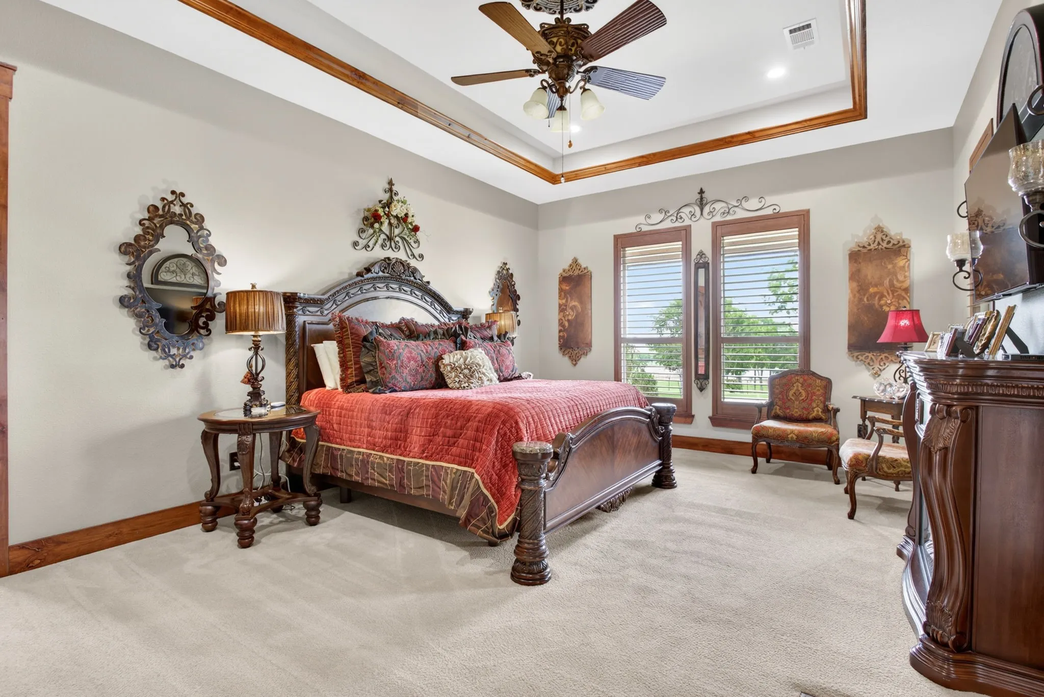 Spacious room featuring neutral carpeting and a tray ceiling with wood-finish trim