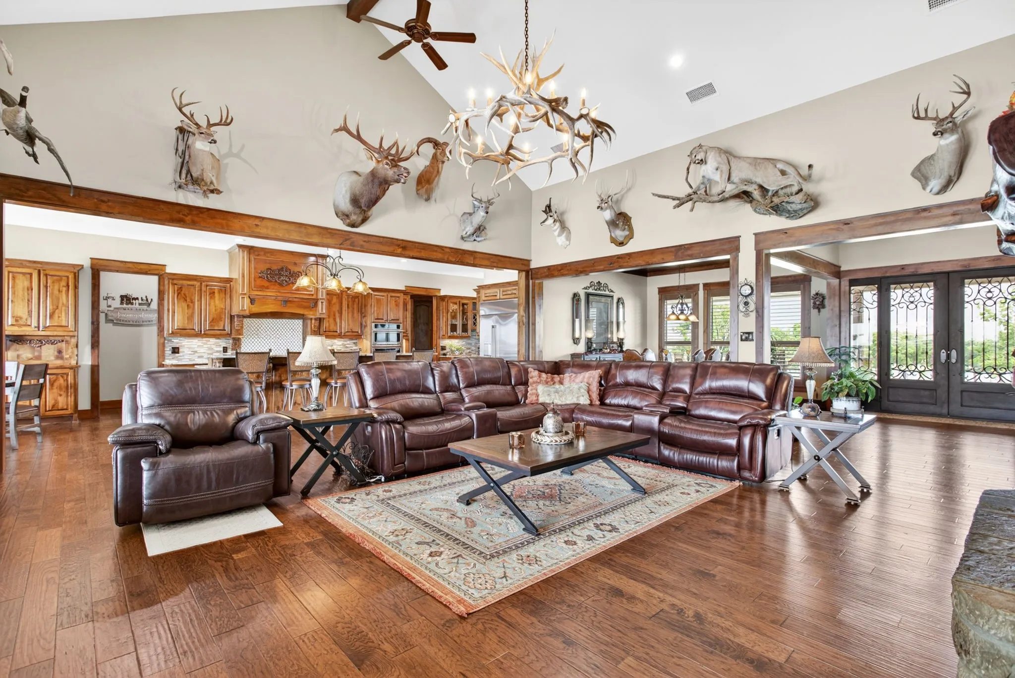 Spacious living area featuring high vaulted ceilings, robust wood-finish flooring, and exposed wood beams