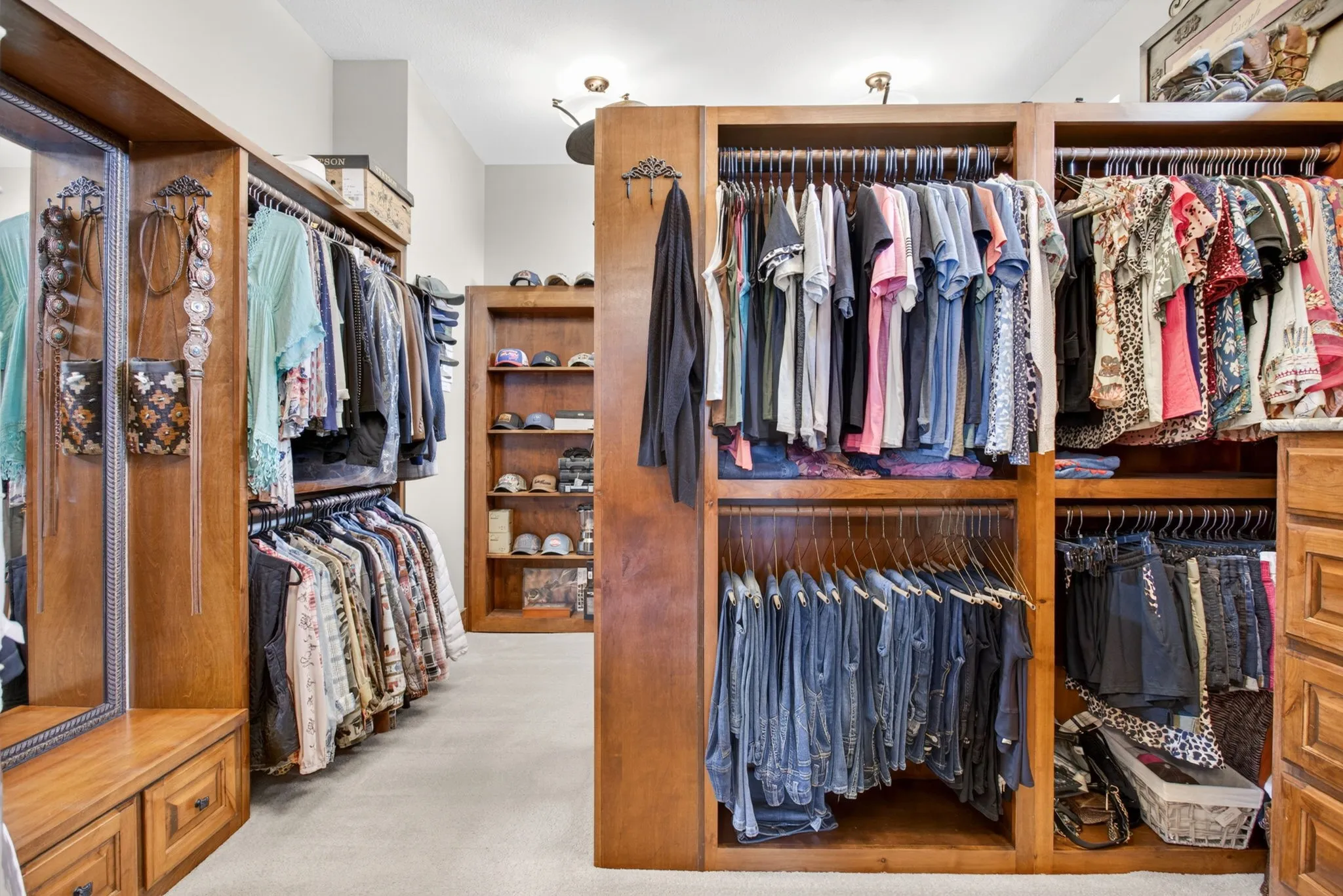 Custom wood-finish cabinetry featuring multiple hanging rods, built-in shelving, and drawers