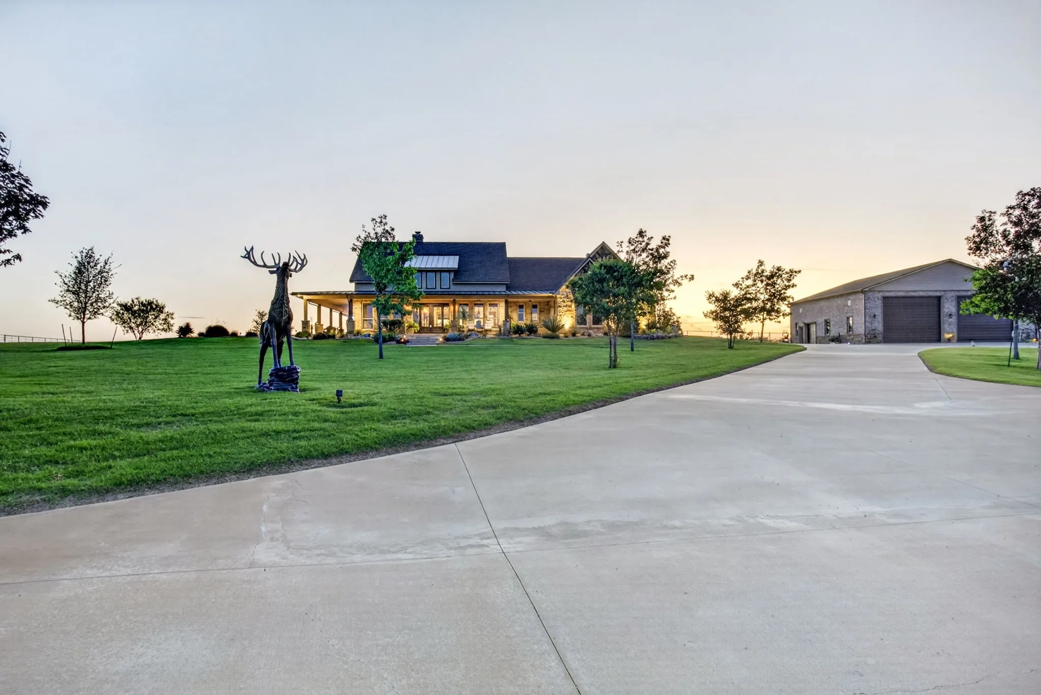 Concrete driveway leading to a multi-gable residence and a detached garage structure