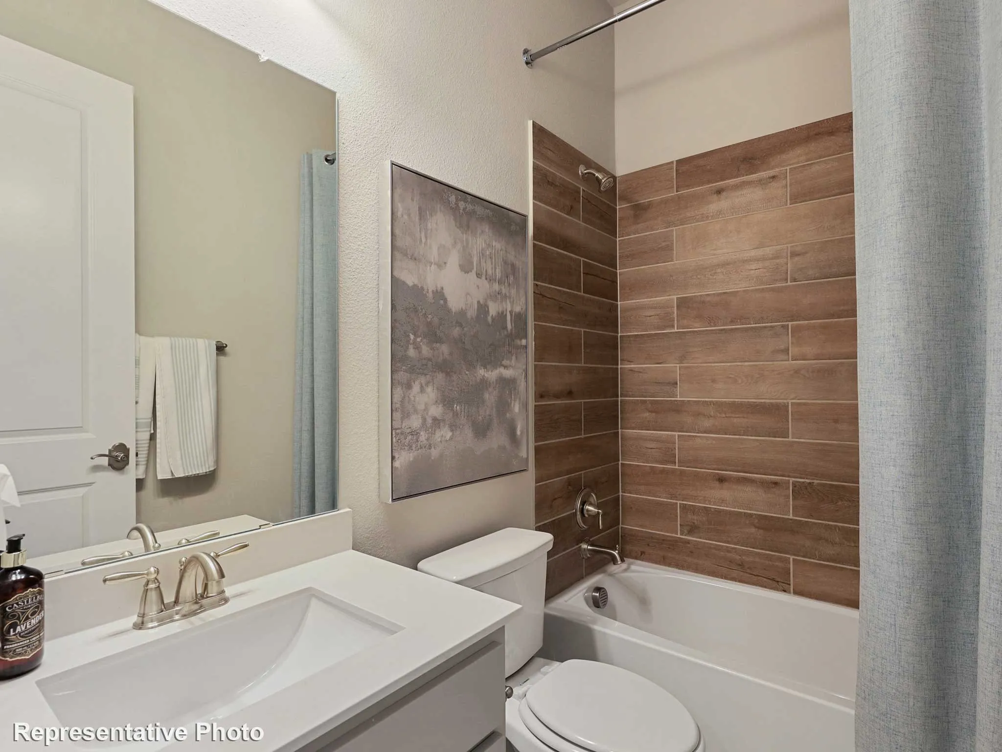 Bathroom featuring a vanity with an integrated sink, brushed nickel faucet, and a large mirror