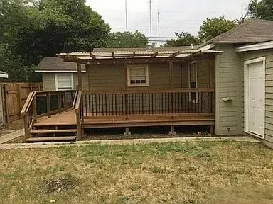 Rear deck with wood flooring and railing, featuring clear panel accents, a multi-level design, and a translucent overhead covering