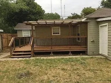 Wood deck featuring a covered patio, staircase entry, and integrated wooden railing