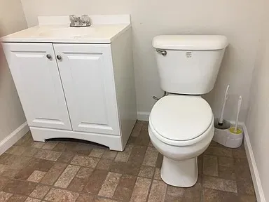 Bathroom featuring a white vanity with an integrated sink, polished chrome faucet, and panel-front cabinetry