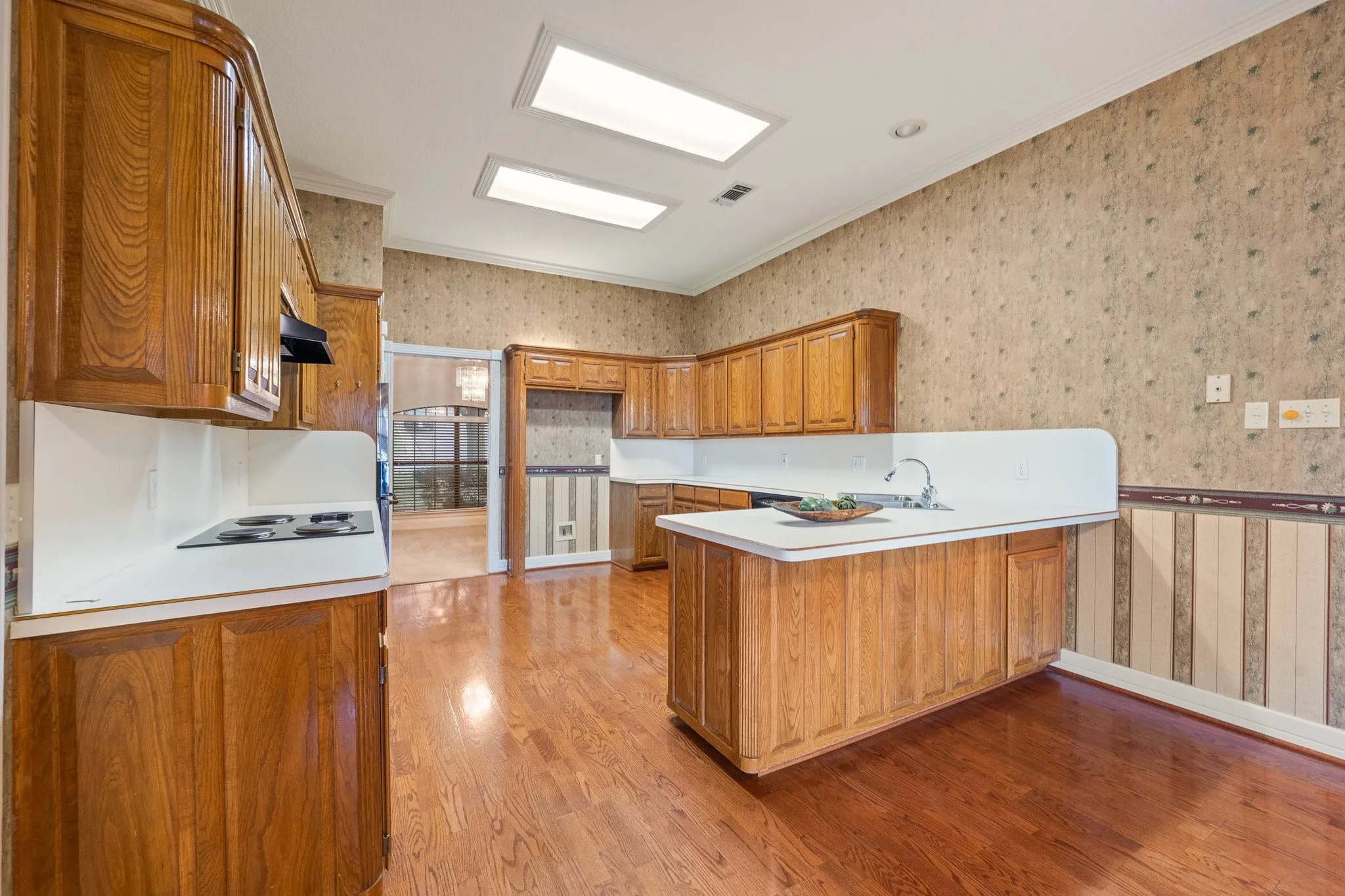 Kitchen featuring wood-finish flooring, recessed lighting, wood cabinetry, and white countertops