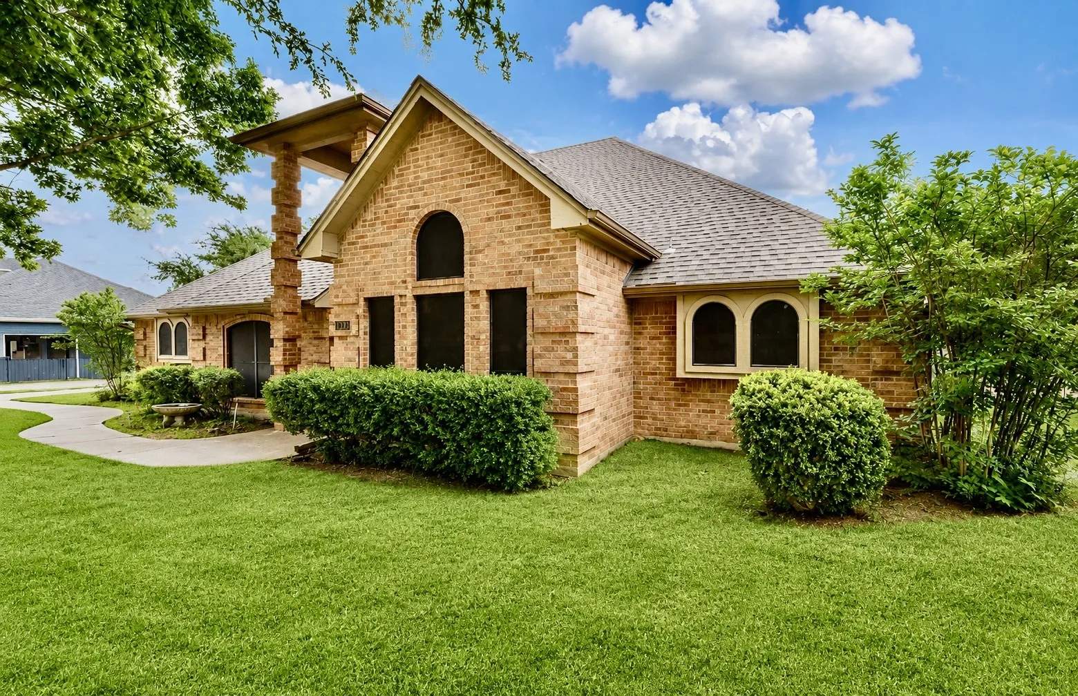 Brick facade with arched windows and a prominent stone column detail
