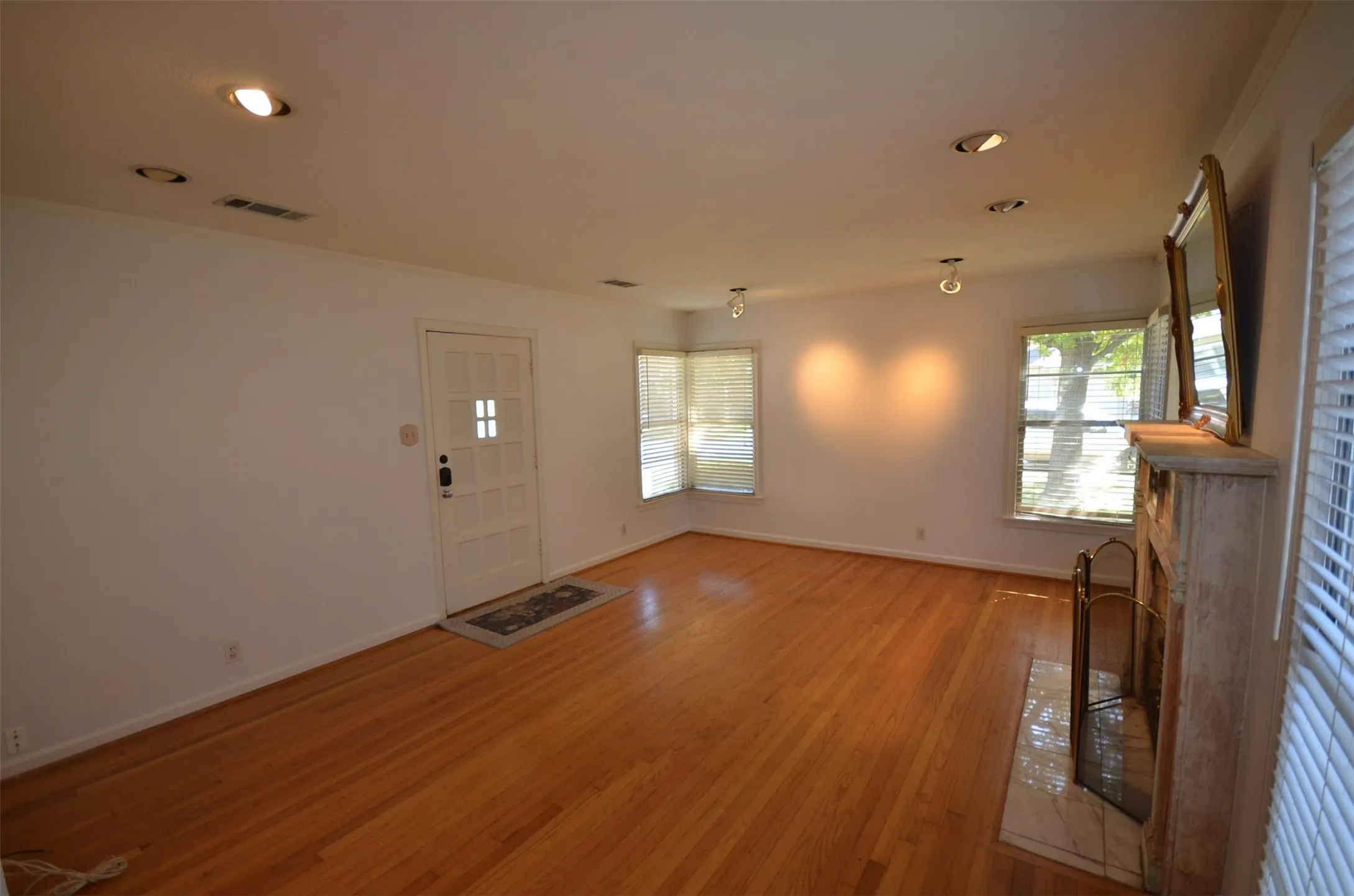Living area featuring wood-finish flooring, recessed lighting, and a front entry door with glass paneling